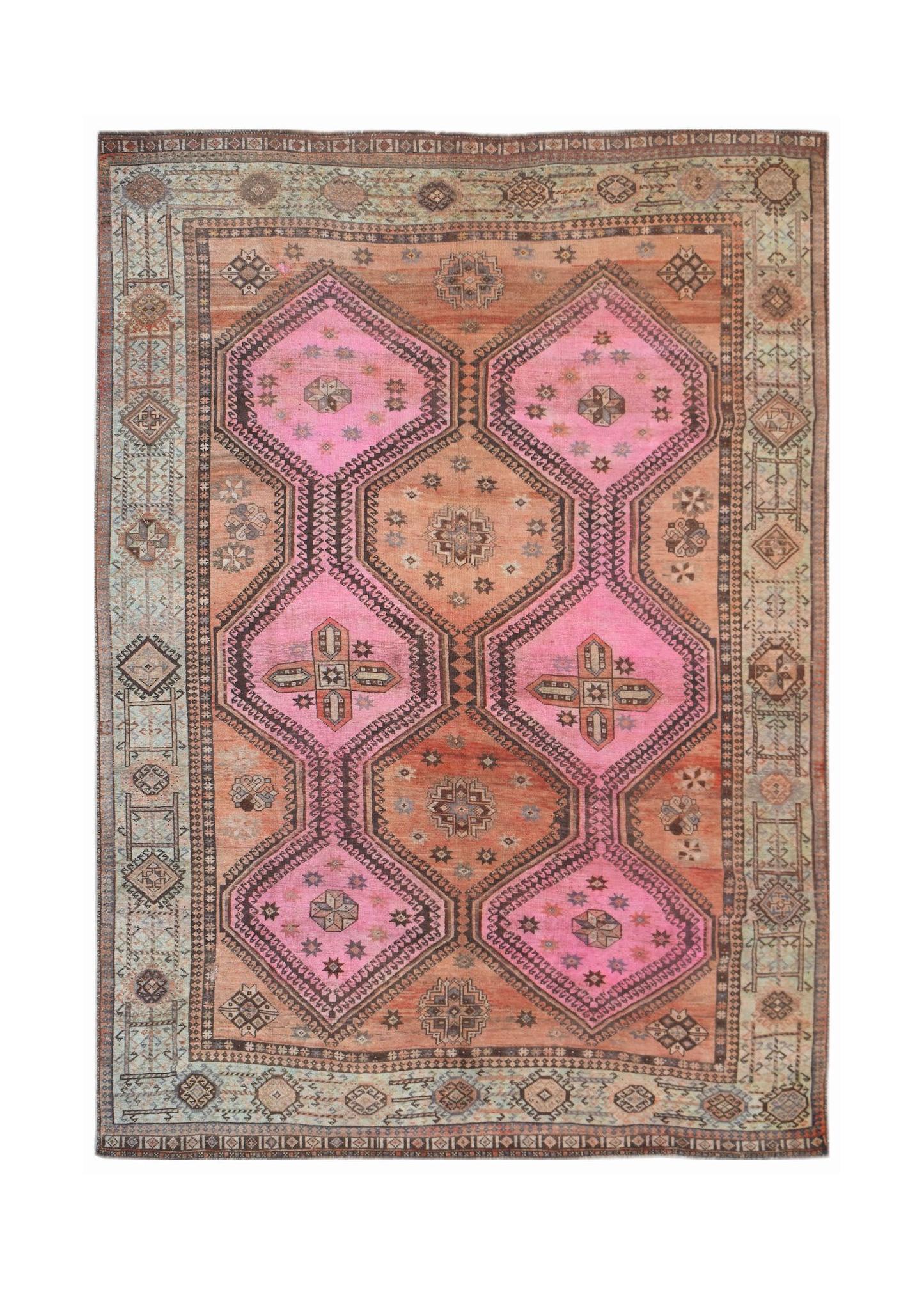 A vintage Persian Hamadan rug featuring pink and orange geometric medallions on a wool field.