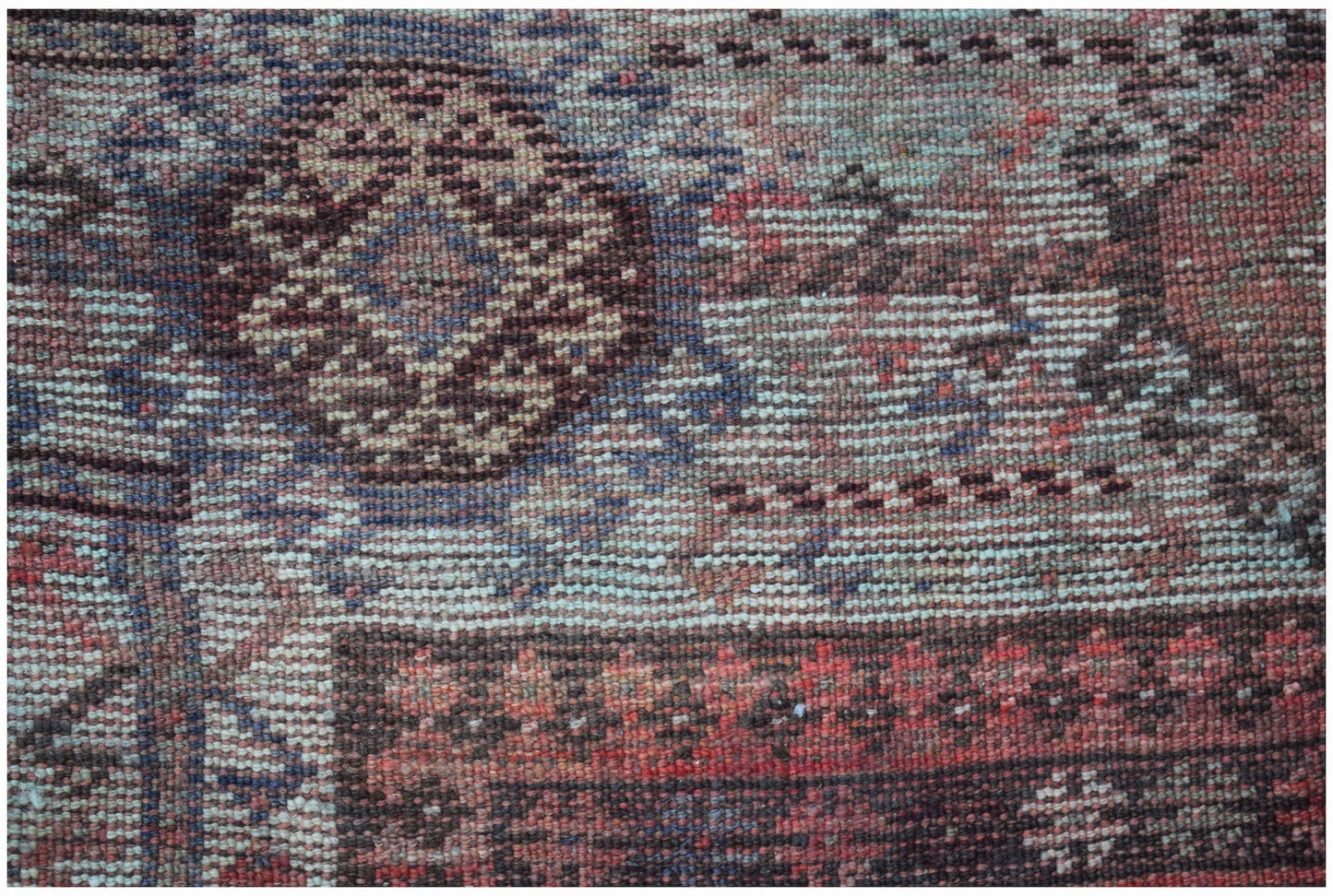 A close-up of a vintage handwoven Persian Hamadan rug featuring intricate geometric patterns.
