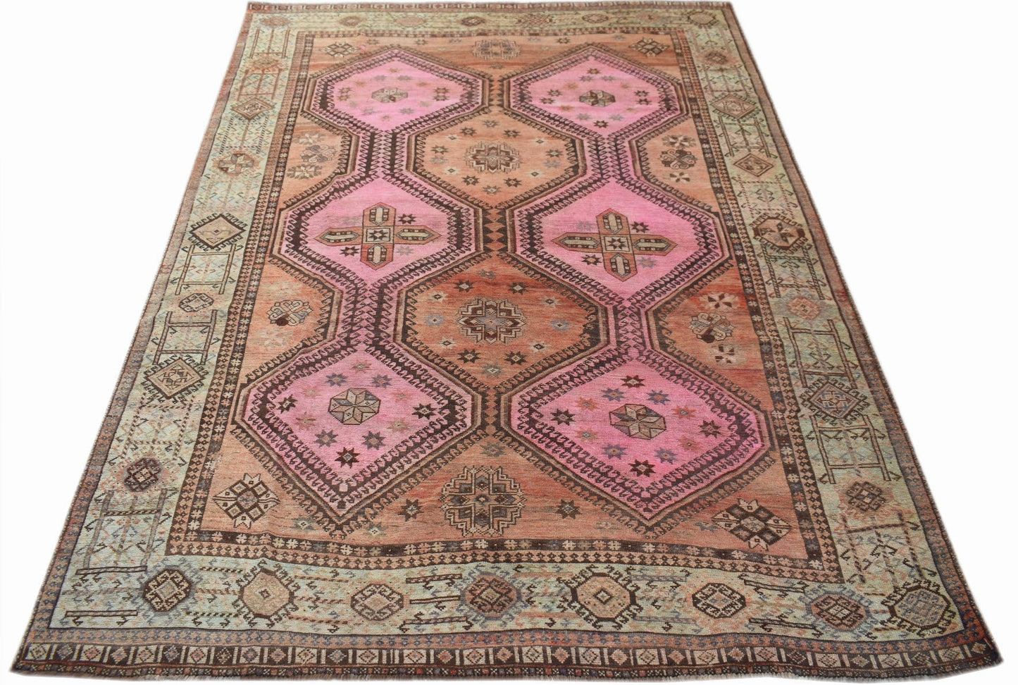 A vintage Persian Hamadan rug featuring pink and orange geometric medallions on a patterned field.