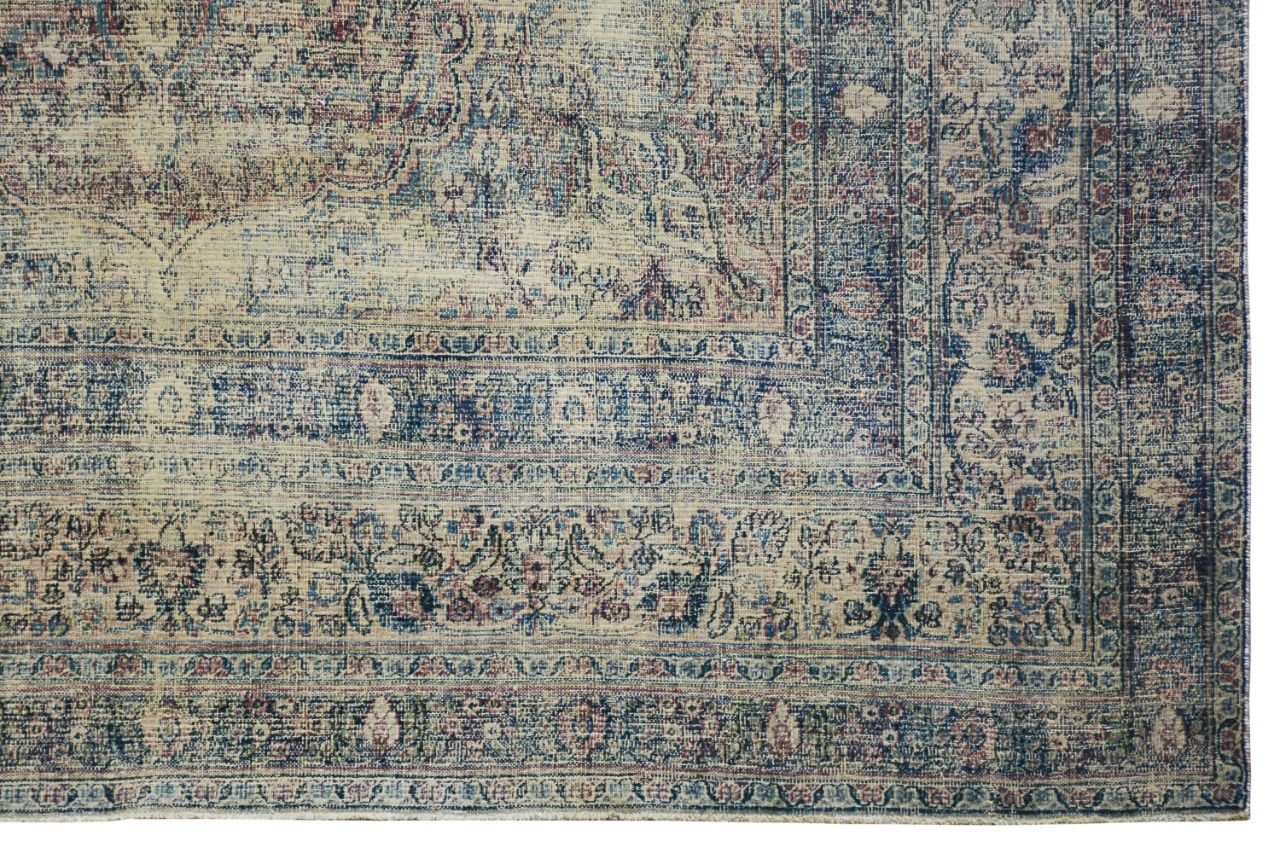 An antique Persian Kerman rug featuring a faded blue and cream floral medallion pattern.