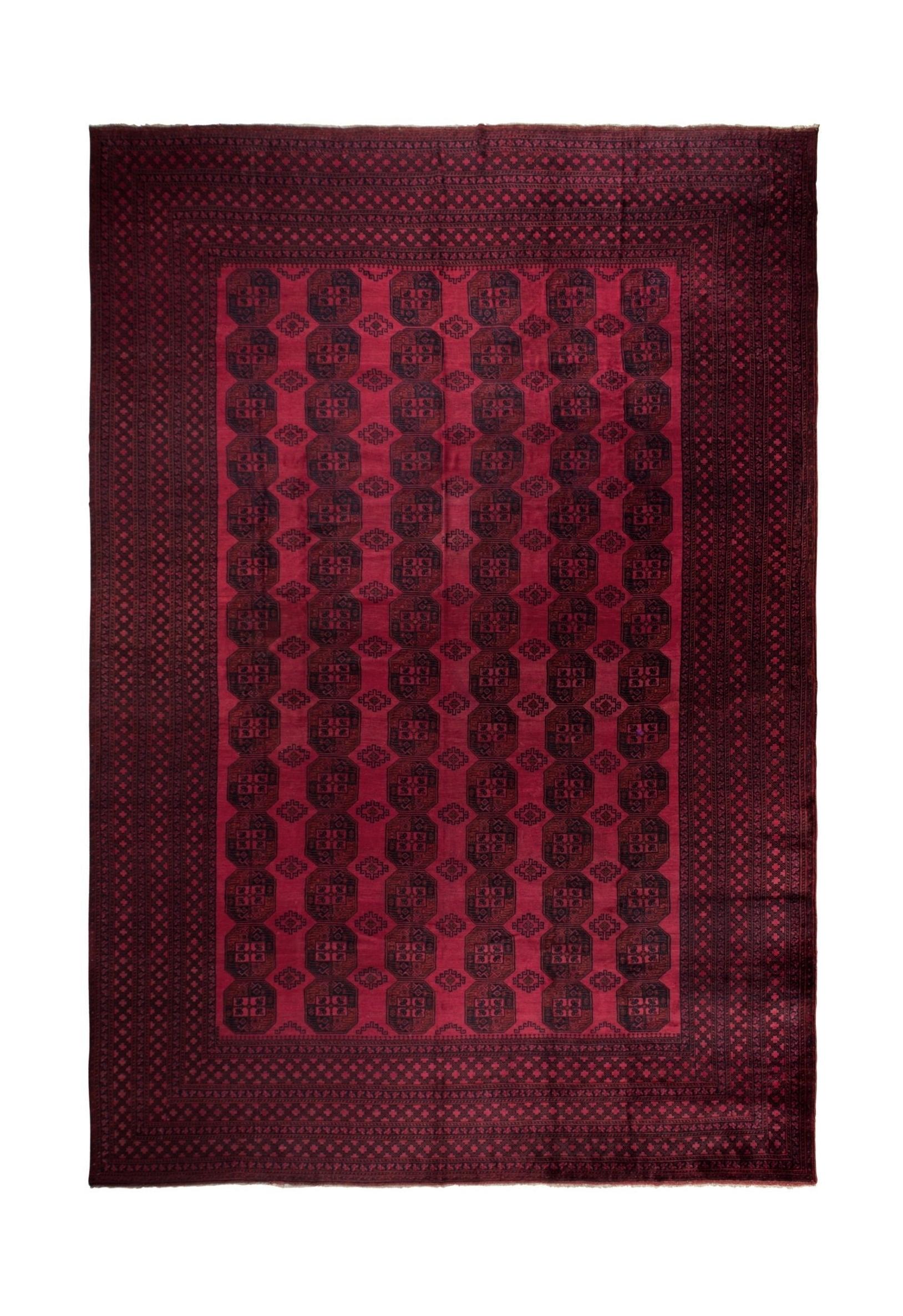 An antique Afghan Turkmen rug featuring a repeating geometric octagonal pattern in deep red.