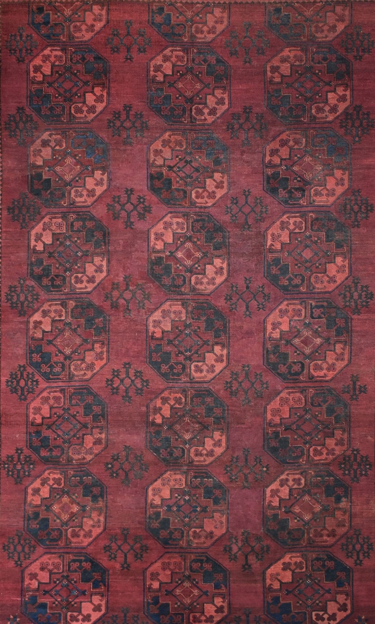 Antique Afghan Turkmen rug featuring a repeating geometric octagonal pattern in red and dark blue.