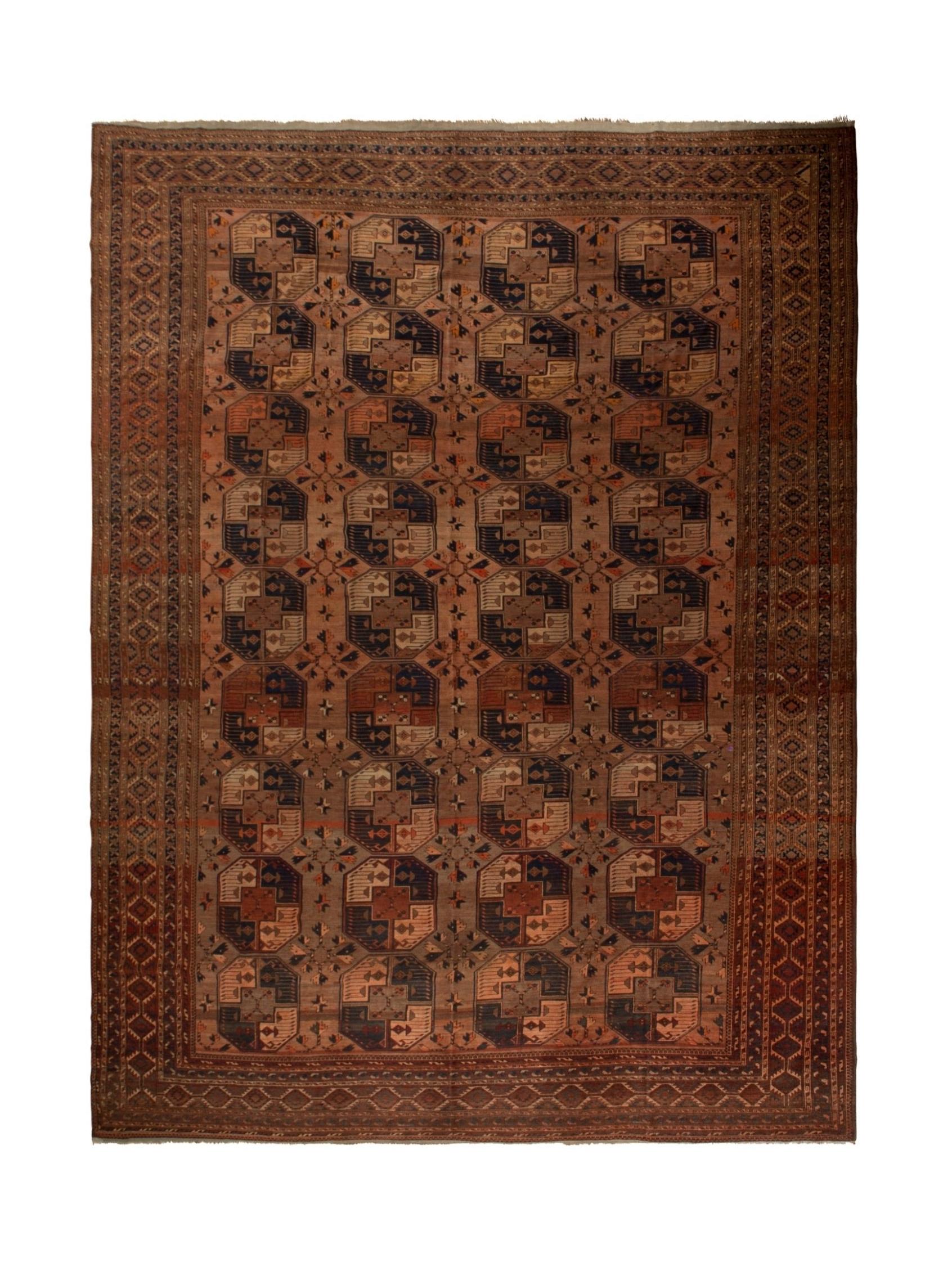 An antique handmade Afghan Turkmen wool rug featuring a repeating geometric octagonal pattern.