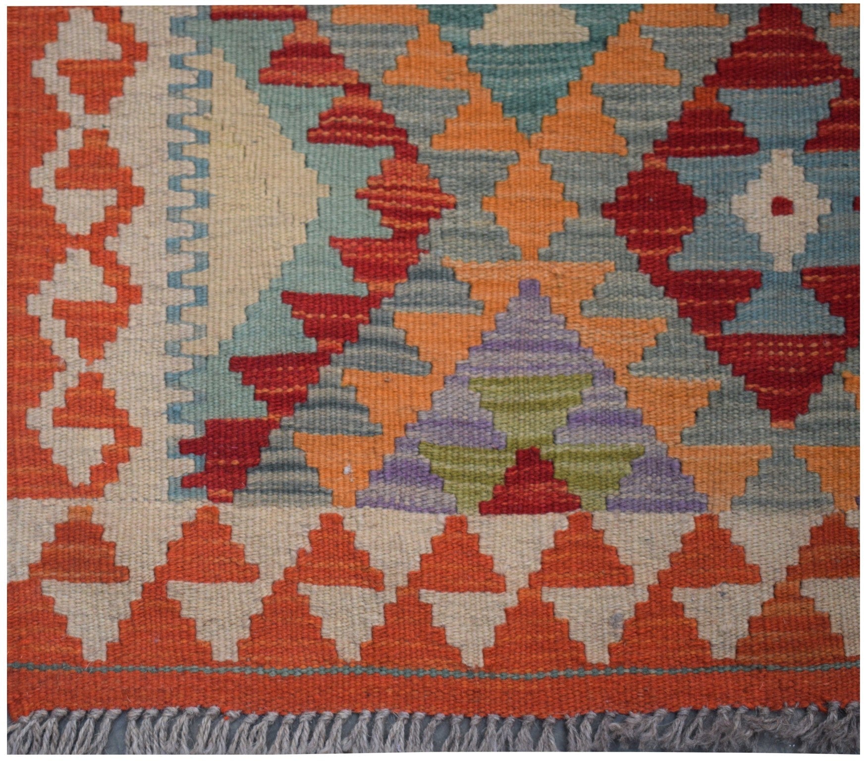 Handmade Afghan Maimana kilim runner featuring a vibrant geometric pattern in wool.