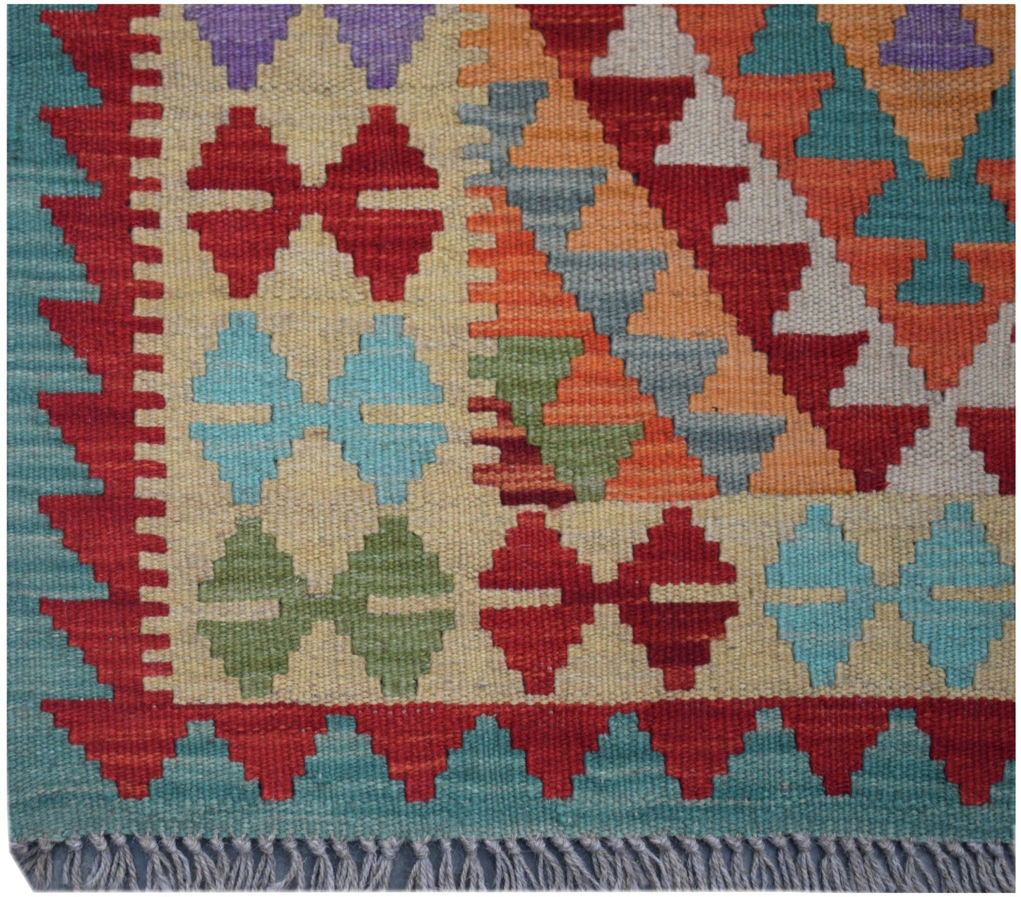 Handmade Afghan Maimana kilim runner featuring a colorful geometric pattern on a cream background.