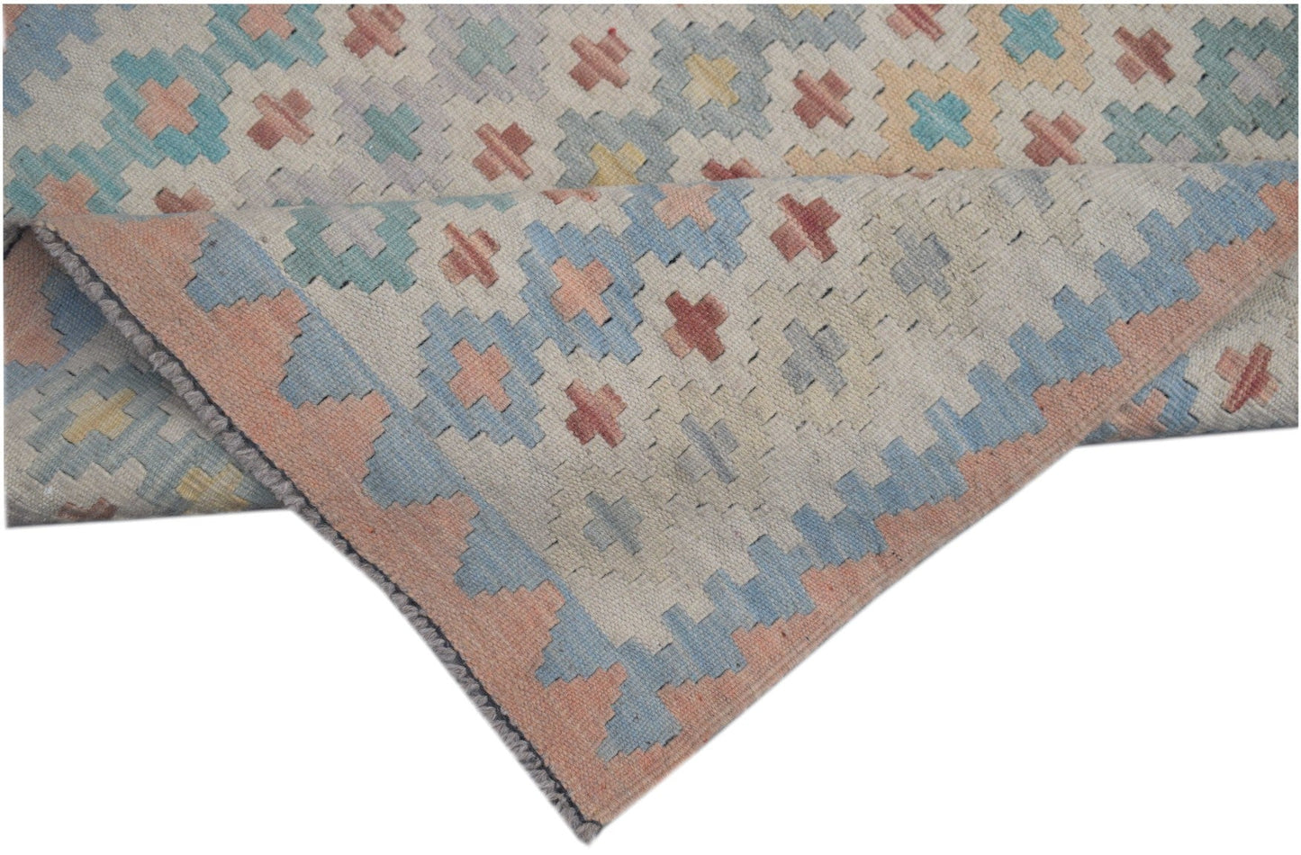 A handmade Afghan Maimana kilim runner featuring a geometric pattern in soft pastel tones.