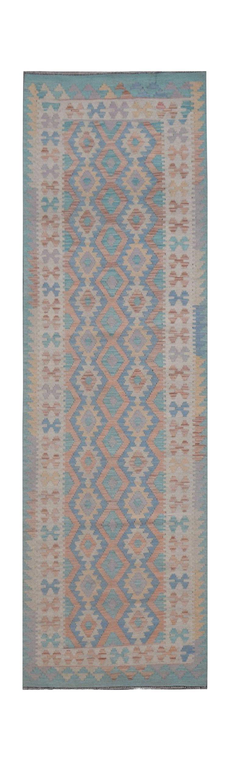A handmade Afghan Maimana wool runner rug featuring a geometric diamond pattern in pastel tones.