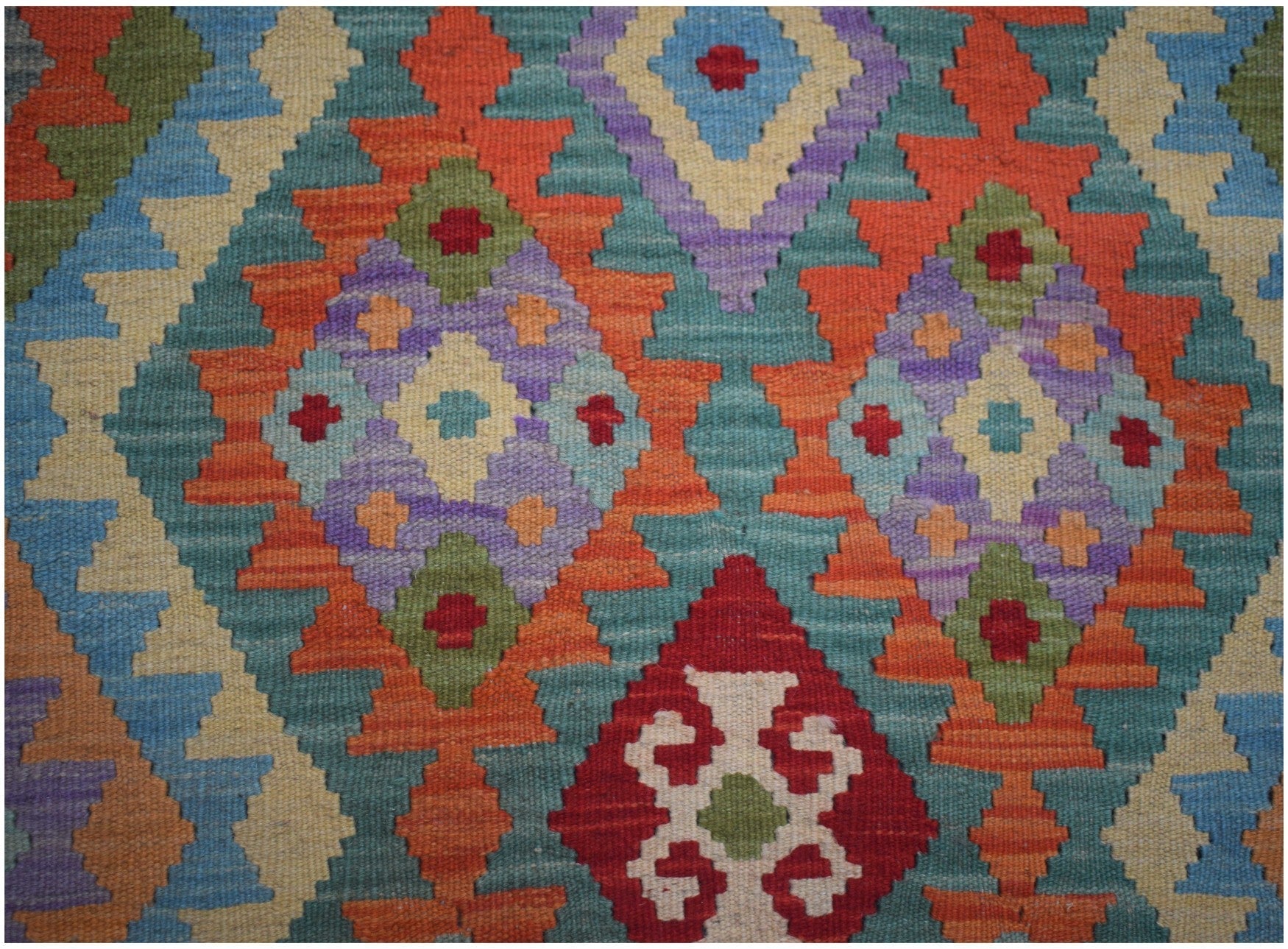 Handmade Afghan Maimana kilim runner featuring a vibrant geometric pattern in wool.
