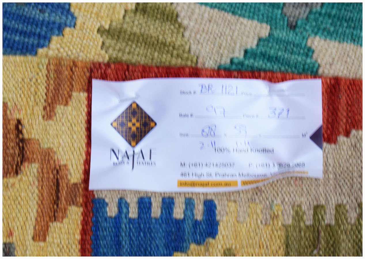 A handwoven Afghan Maimana kilim featuring a vibrant geometric pattern in wool.