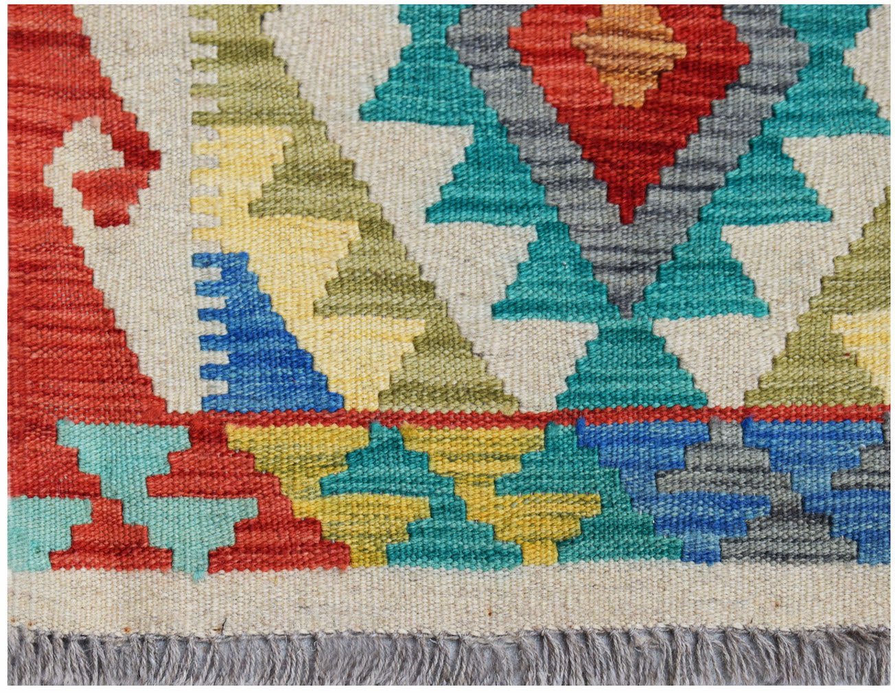 A handmade Afghan Maimana kilim rug featuring a geometric pattern in vibrant, multicolored wool.
