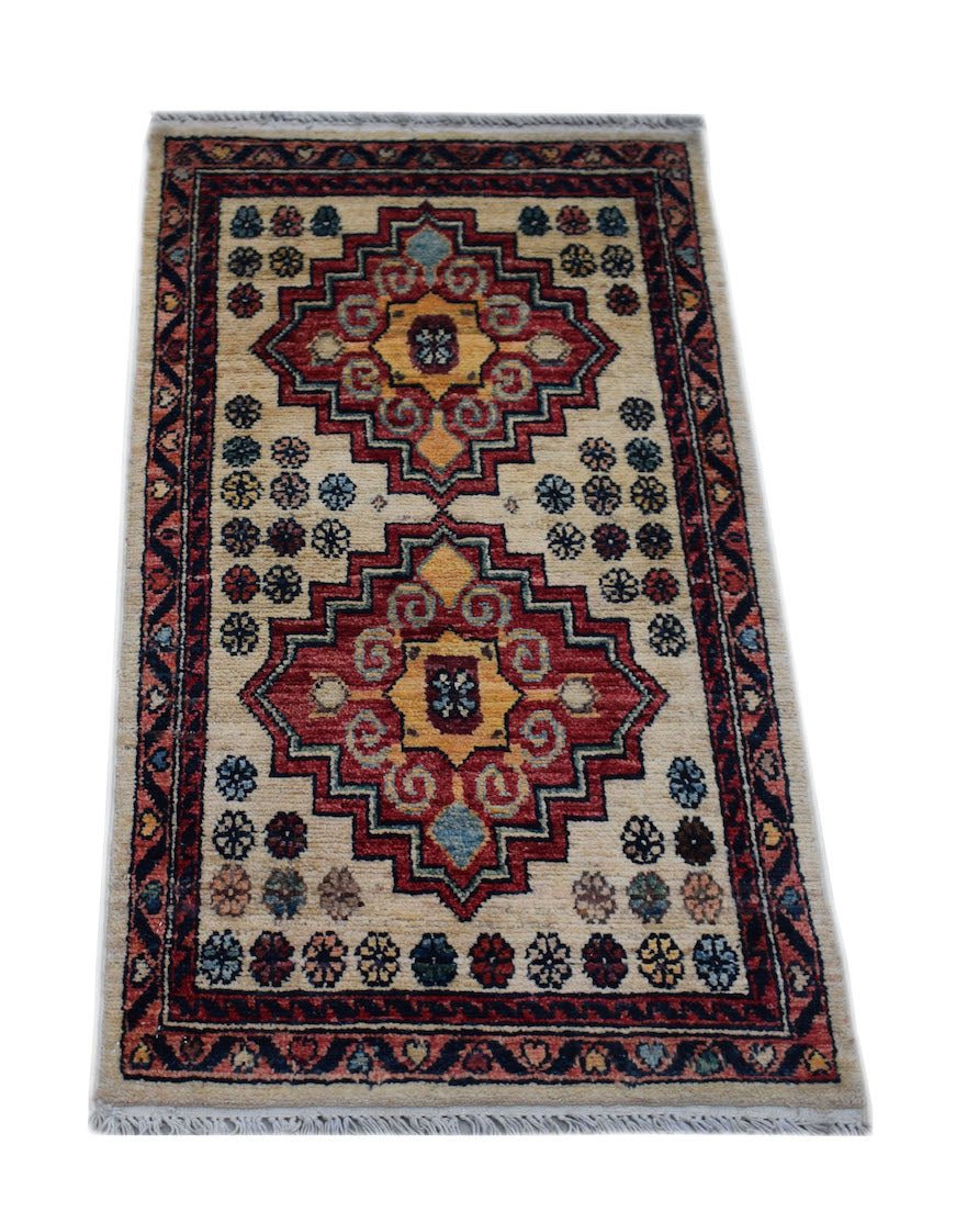 A handmade Afghan Chobi rug featuring two geometric medallions in red and yellow on a cream field.