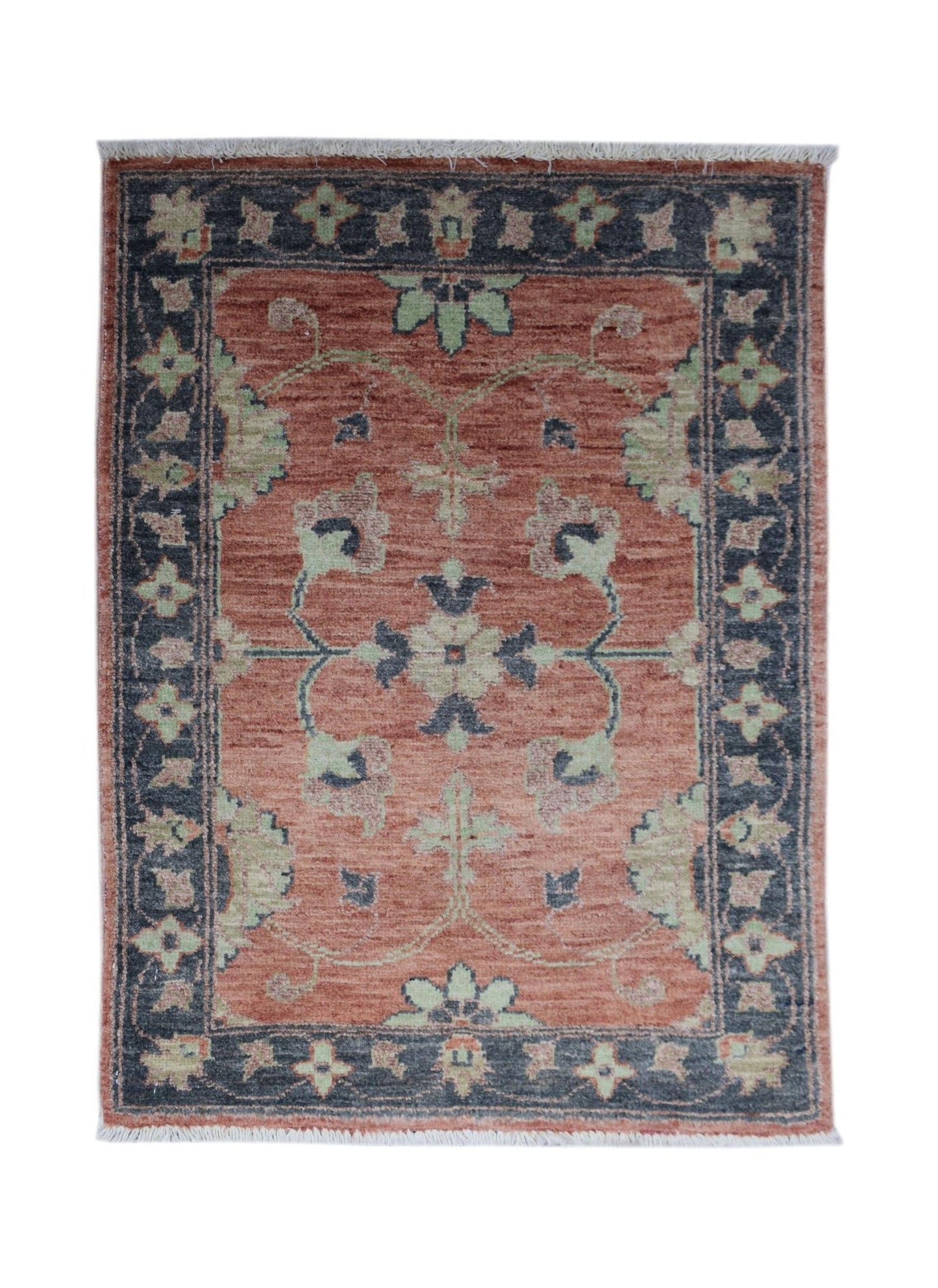 A handmade mini Afghan Chobi rug featuring a floral pattern in rust, sage green, and charcoal.