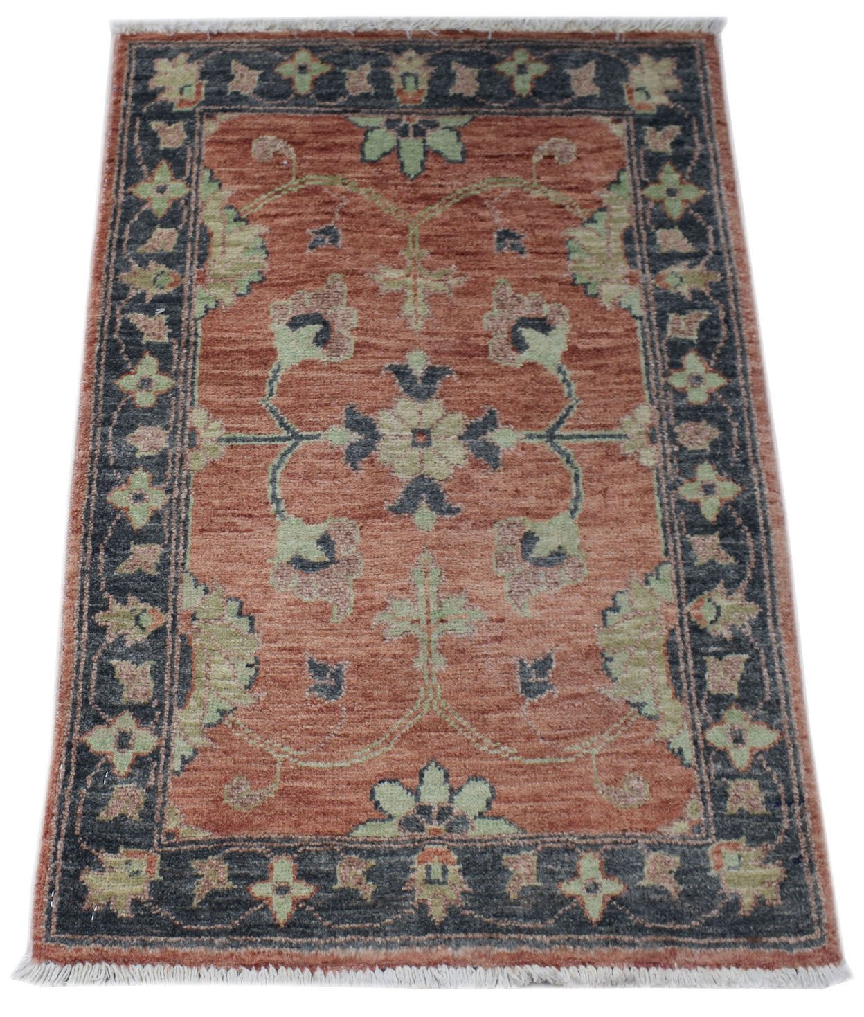 A handmade wool Afghan Chobi rug featuring a floral pattern in rust, sage green, and charcoal.