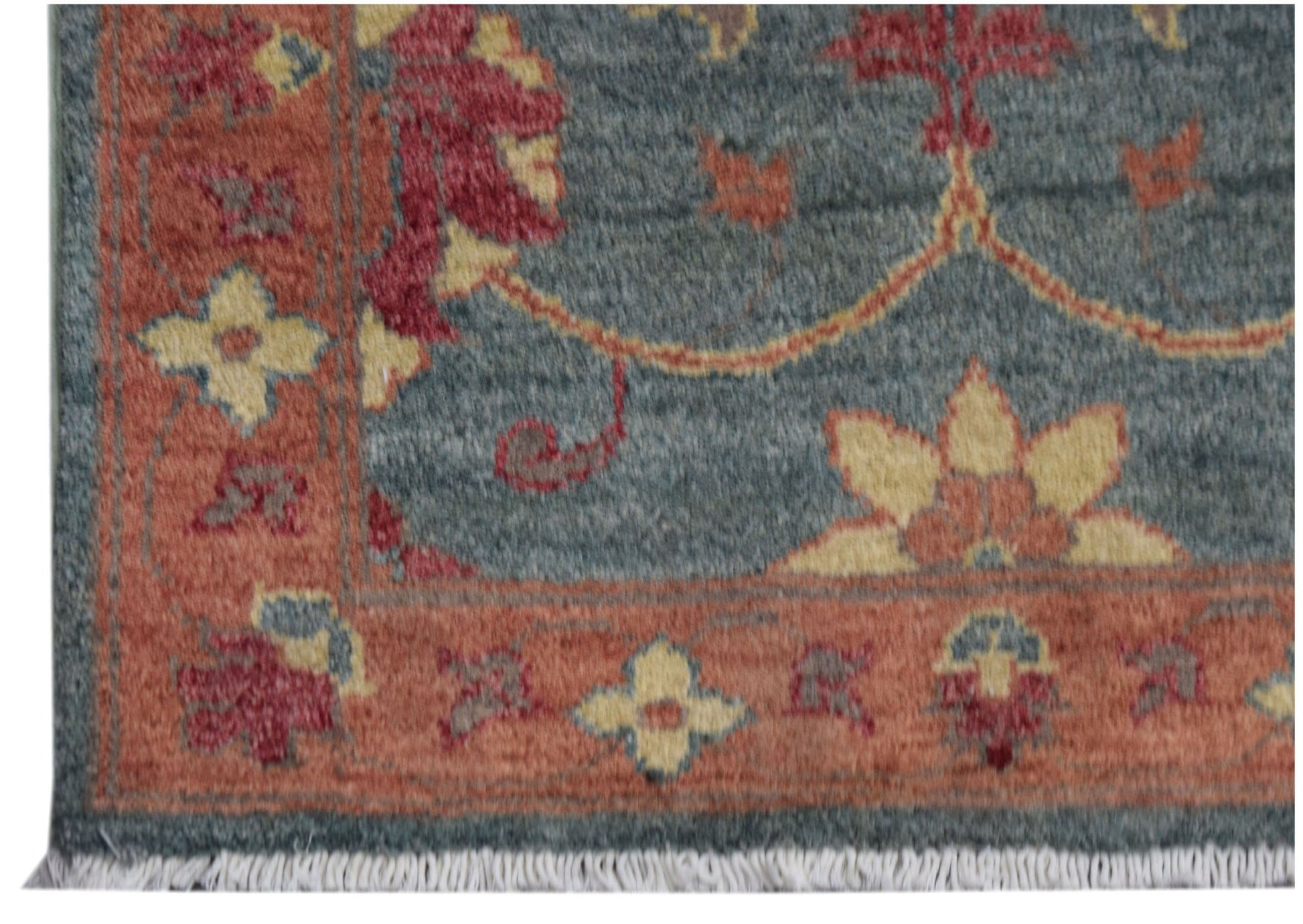 A handmade Afghan Chobi rug featuring a blue field with floral patterns and a rust-colored border.