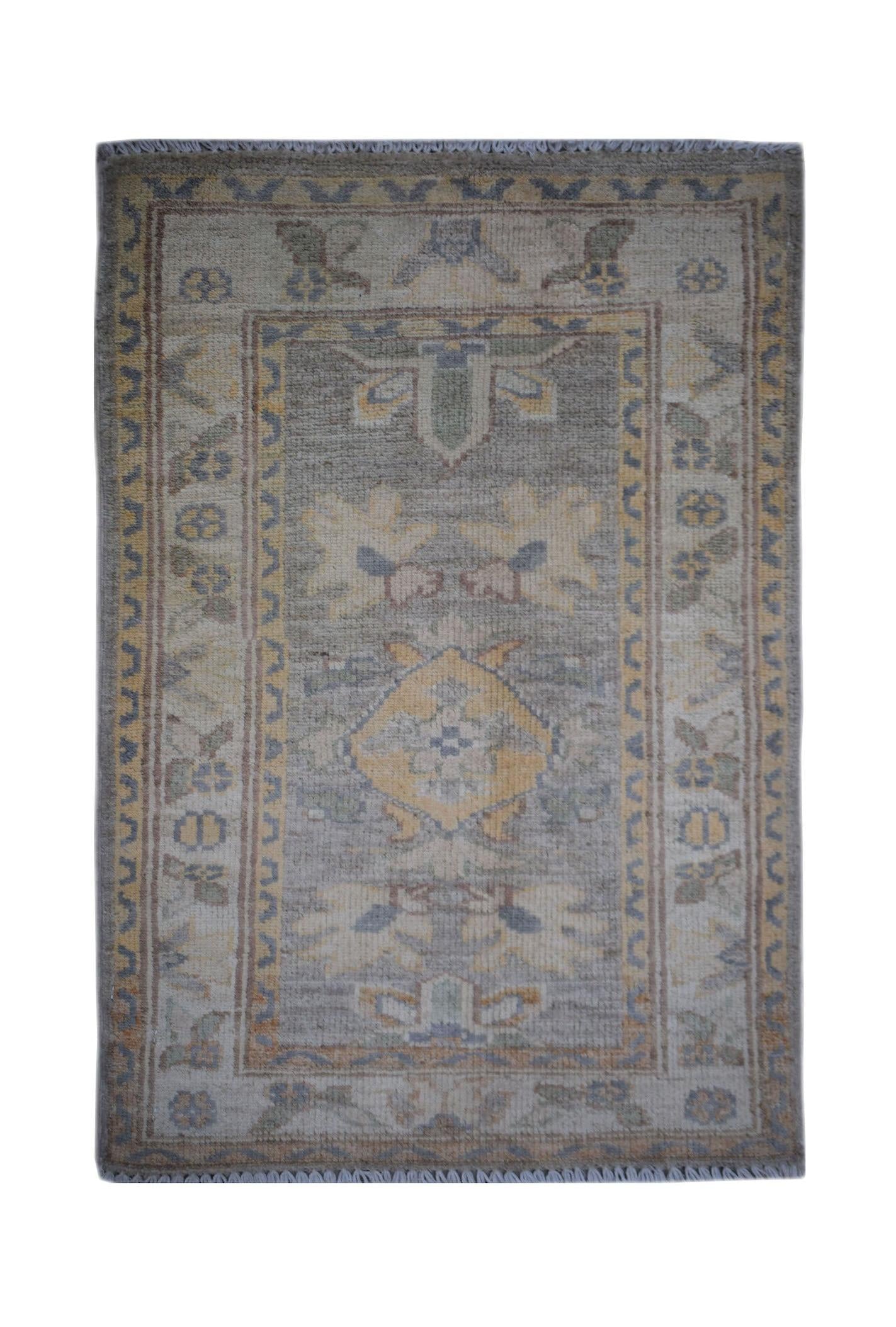 A handmade Afghan Chobi rug featuring a central medallion and floral motifs in muted earth tones.