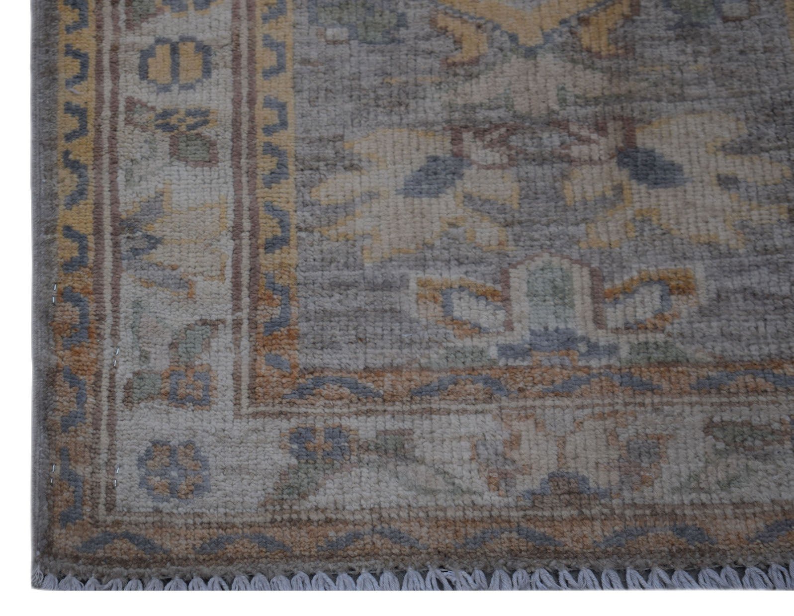 A handmade wool Afghan Chobi rug featuring a traditional floral pattern in muted earth tones.