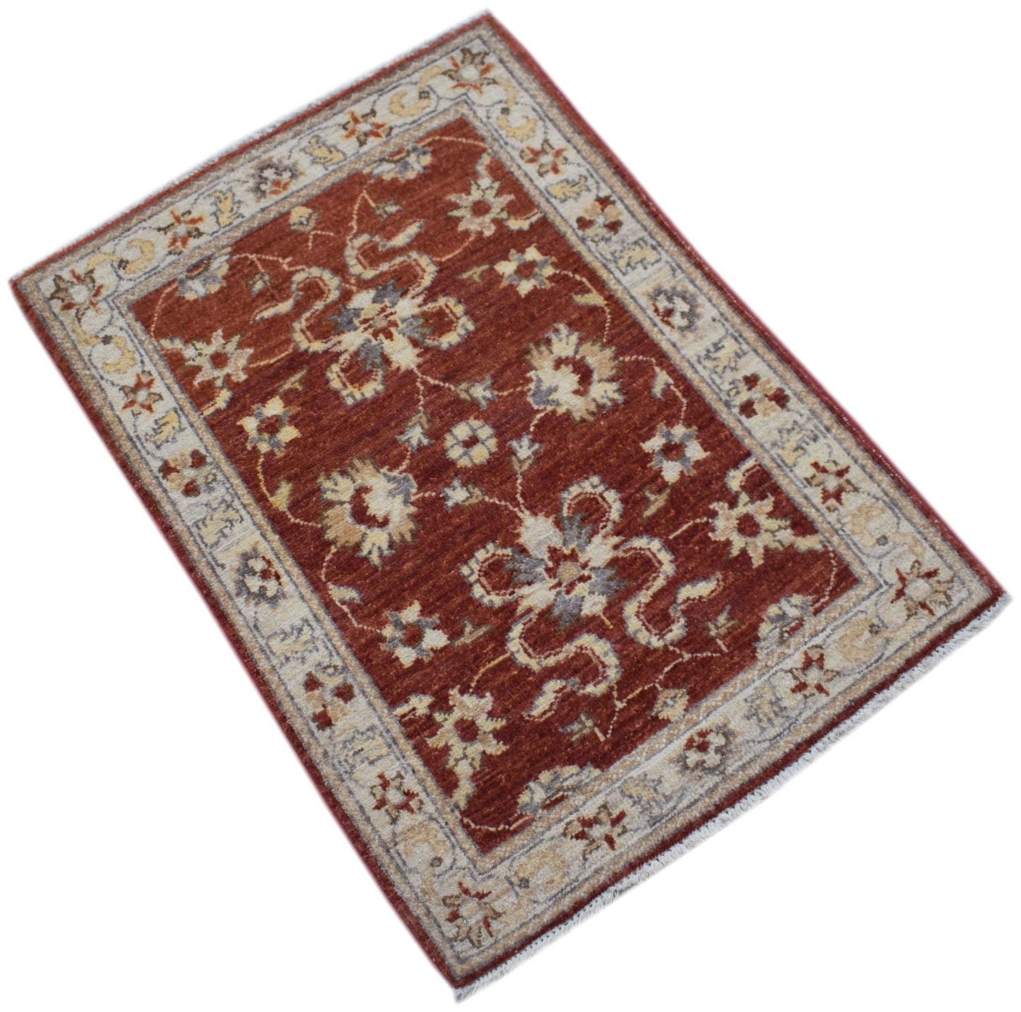A handmade mini Afghan Chobi rug featuring a floral pattern in rust red and cream tones.