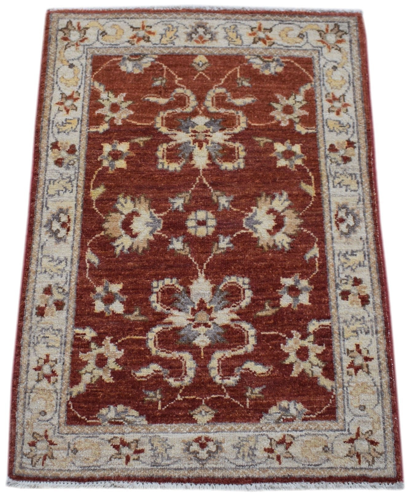 A rectangular handmade Afghan Chobi rug featuring a floral pattern in red, cream, and grey tones.