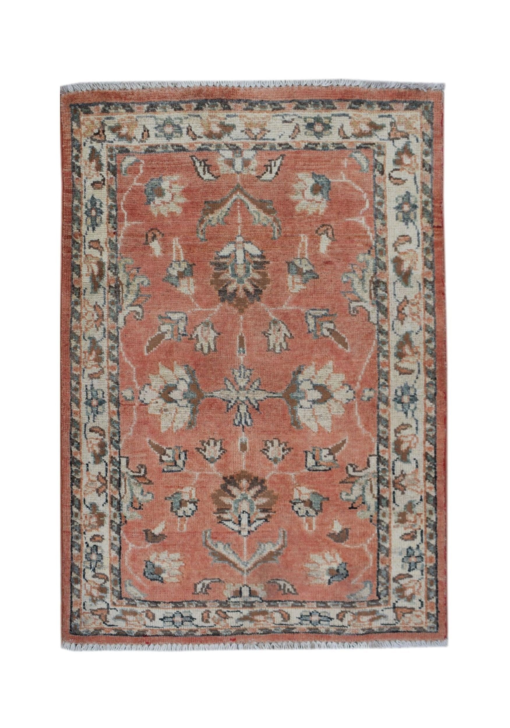 A handmade Afghan Chobi rug featuring a floral pattern in shades of terracotta, cream, and blue.