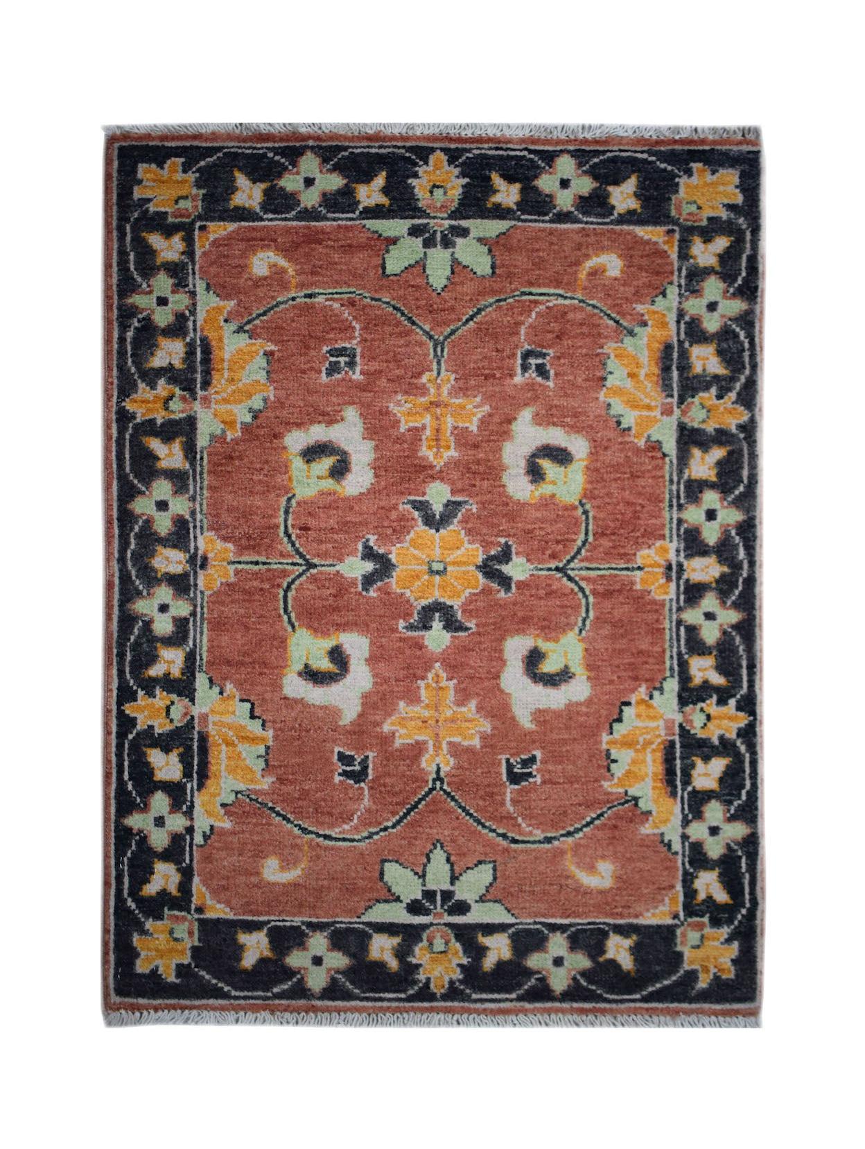 A handmade wool Afghan Chobi rug featuring a floral pattern in rust, yellow, and dark blue.