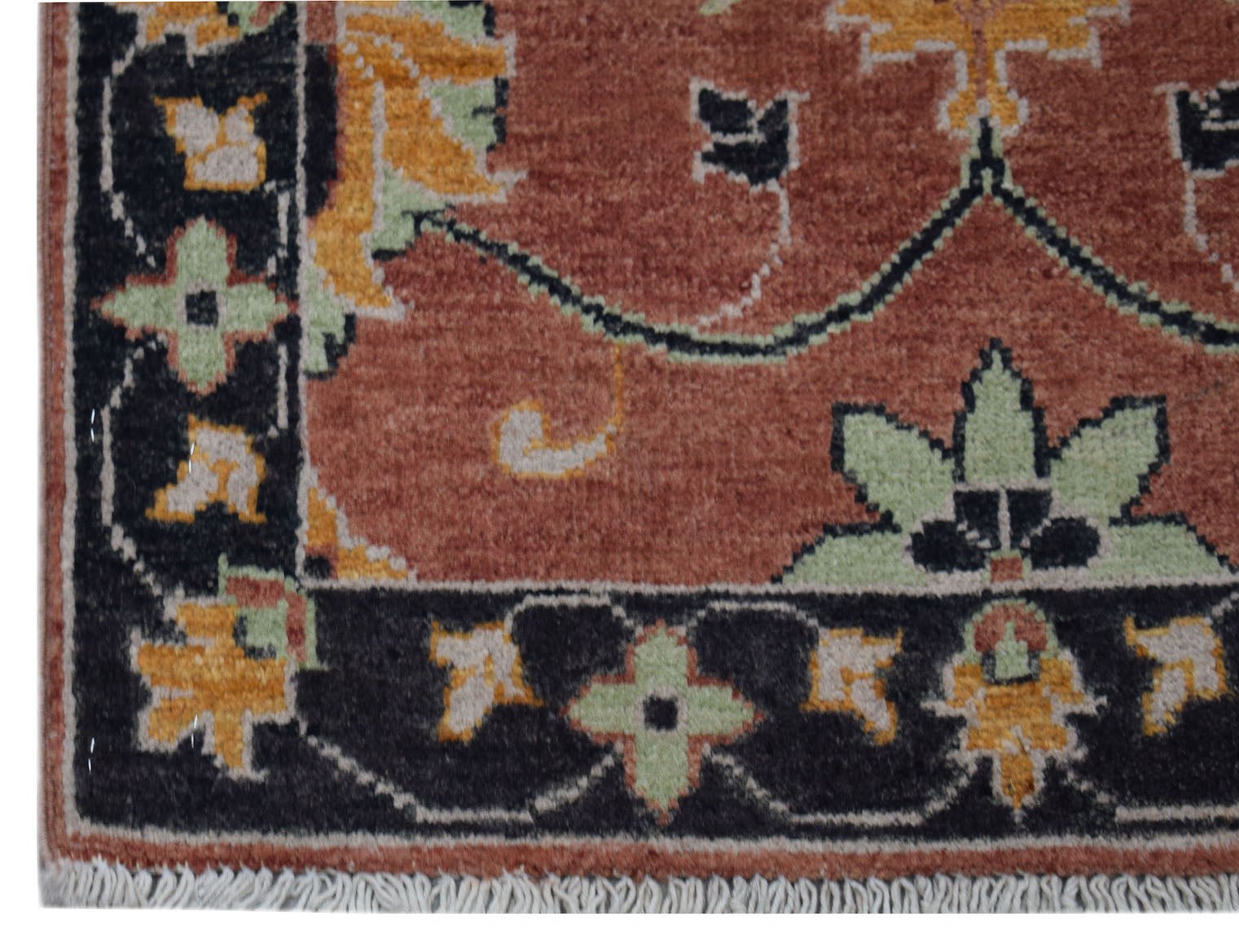 A handmade Afghan Chobi rug featuring a terracotta field with floral patterns and a black border.