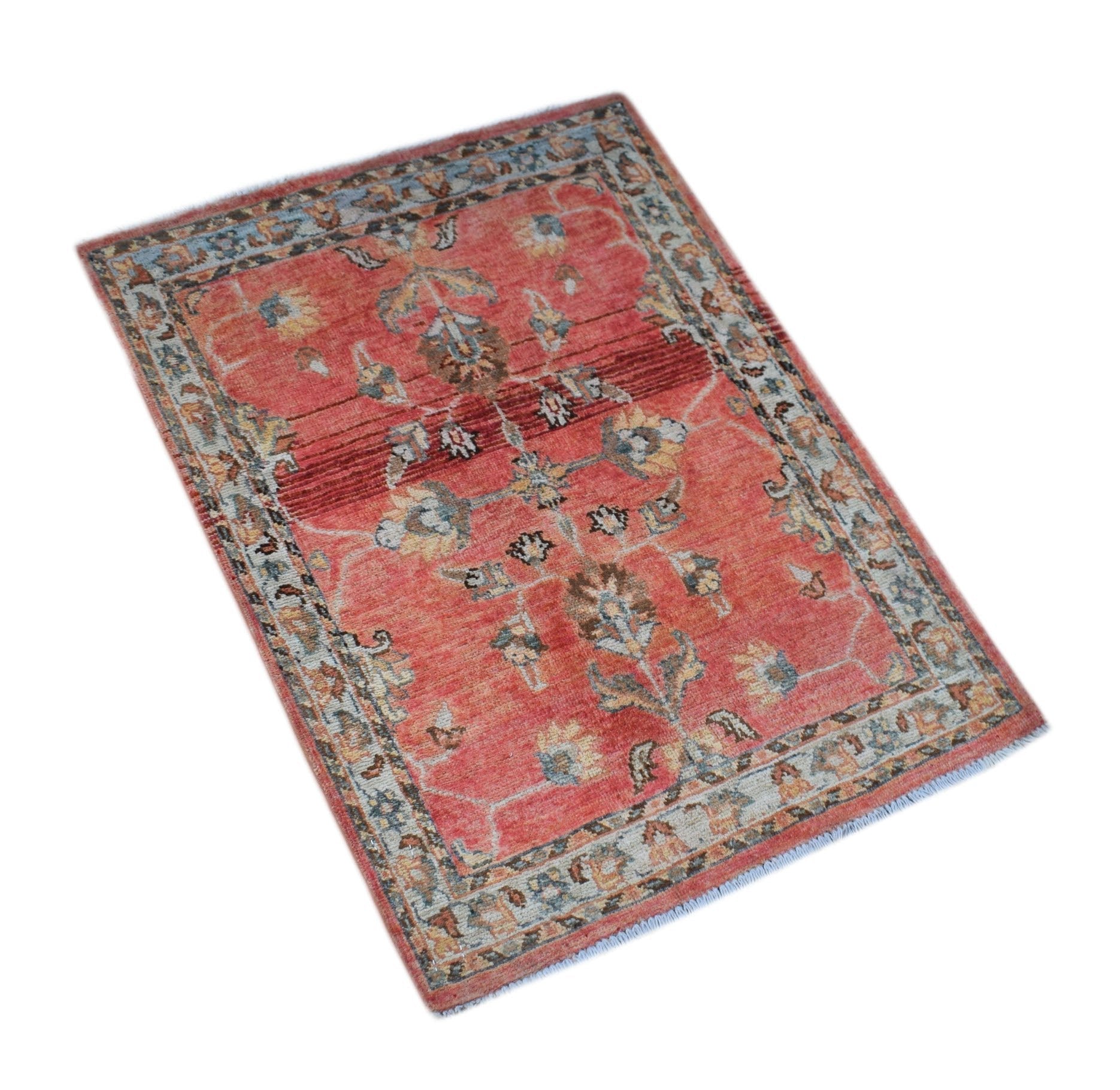 A rectangular handmade Afghan Chobi rug featuring a floral pattern in red, blue, and beige tones.