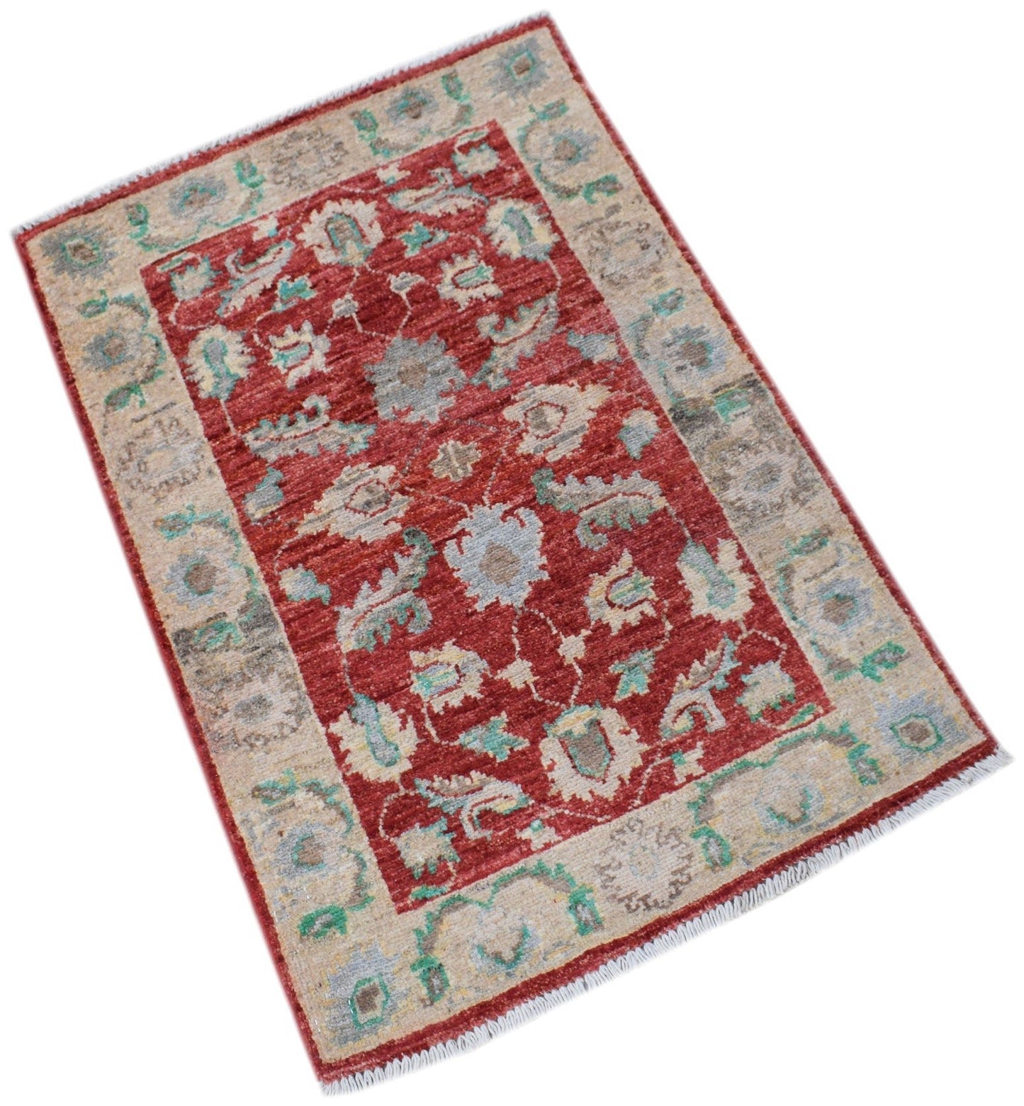 A handmade Afghan Chobi rug featuring a floral pattern in red, beige, and soft blue tones.