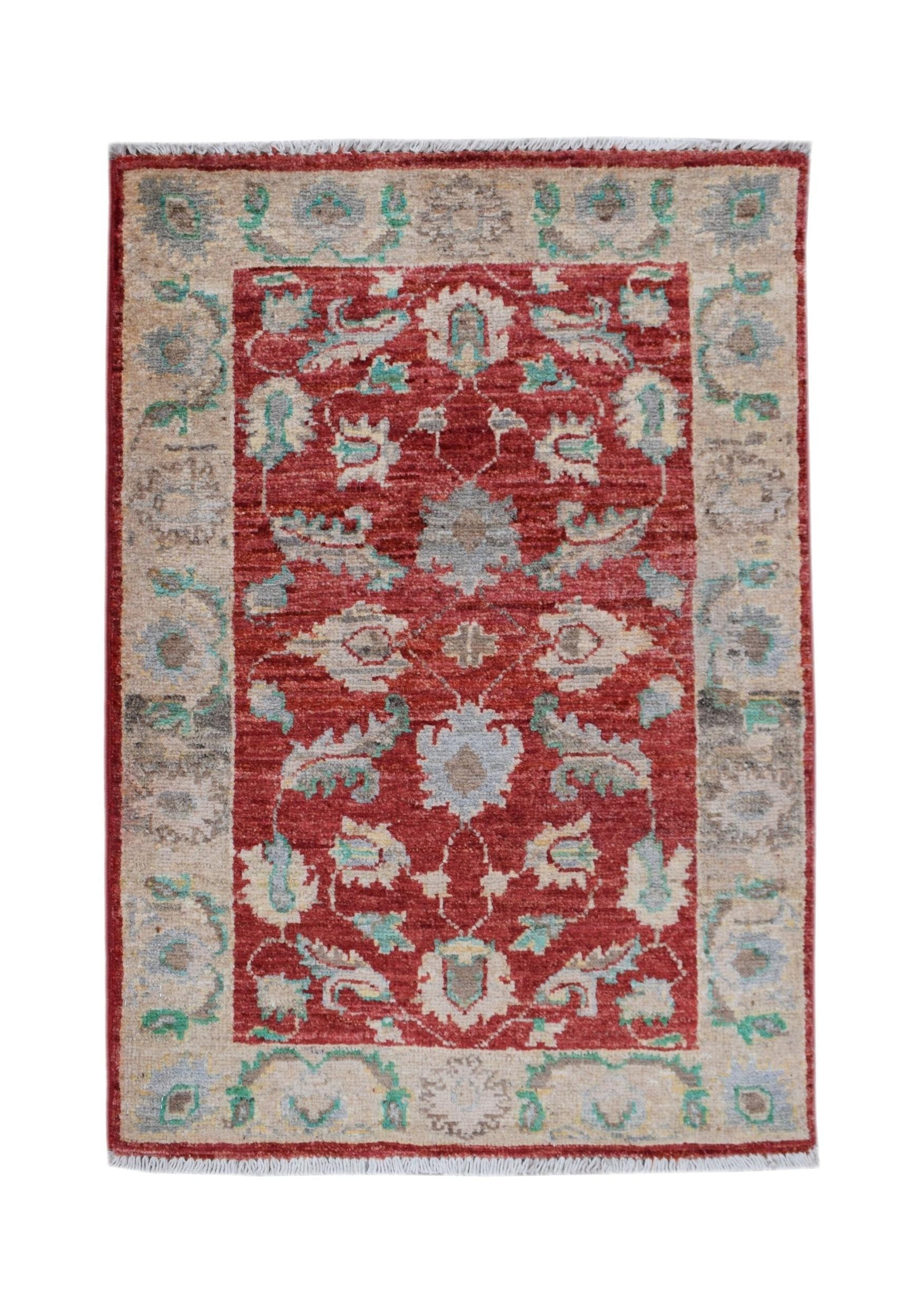 A handmade Afghan Chobi rug featuring a red central field with floral patterns and a beige border.