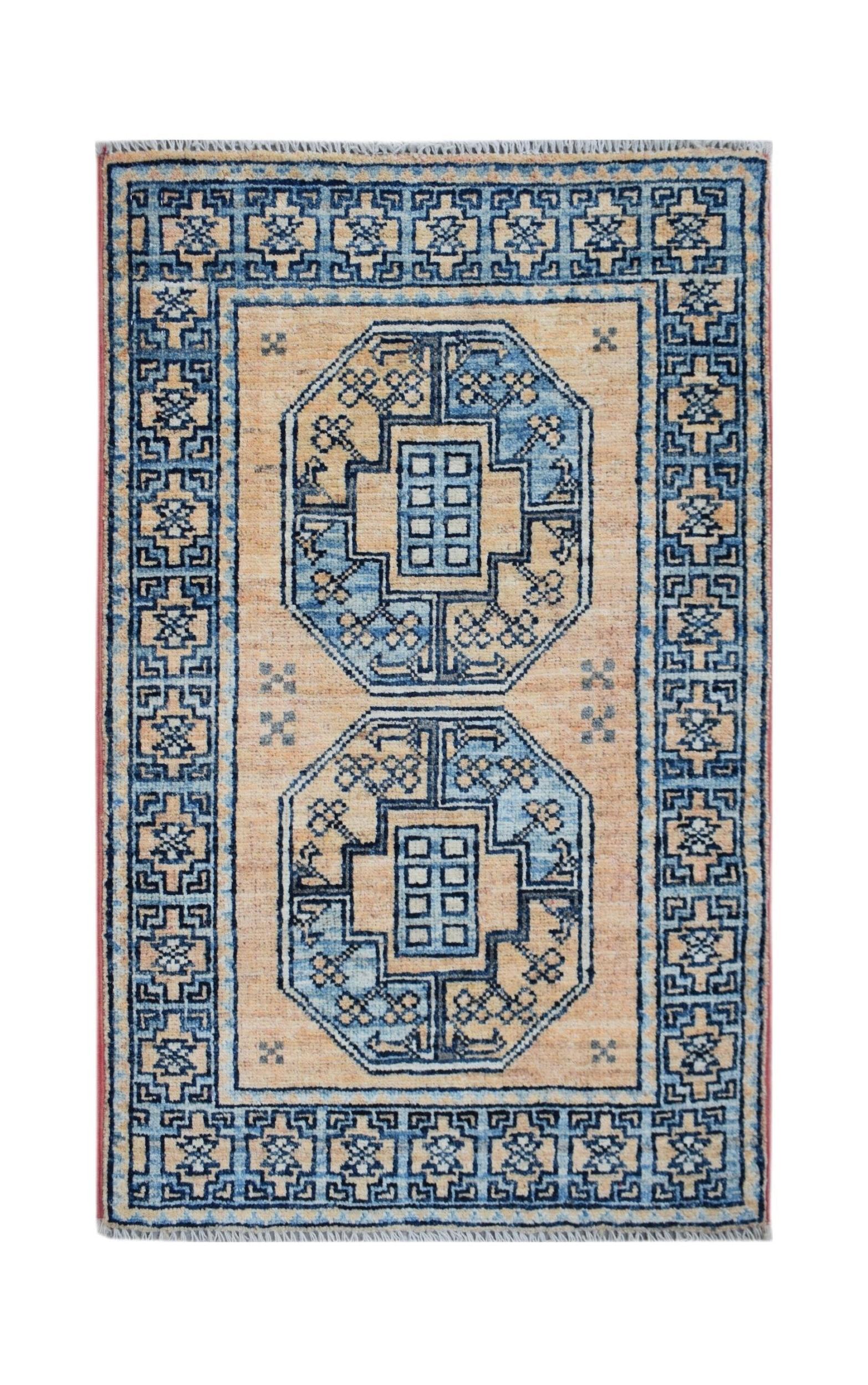 A handmade Afghan Chobi rug featuring two blue octagonal medallions on a tan field.