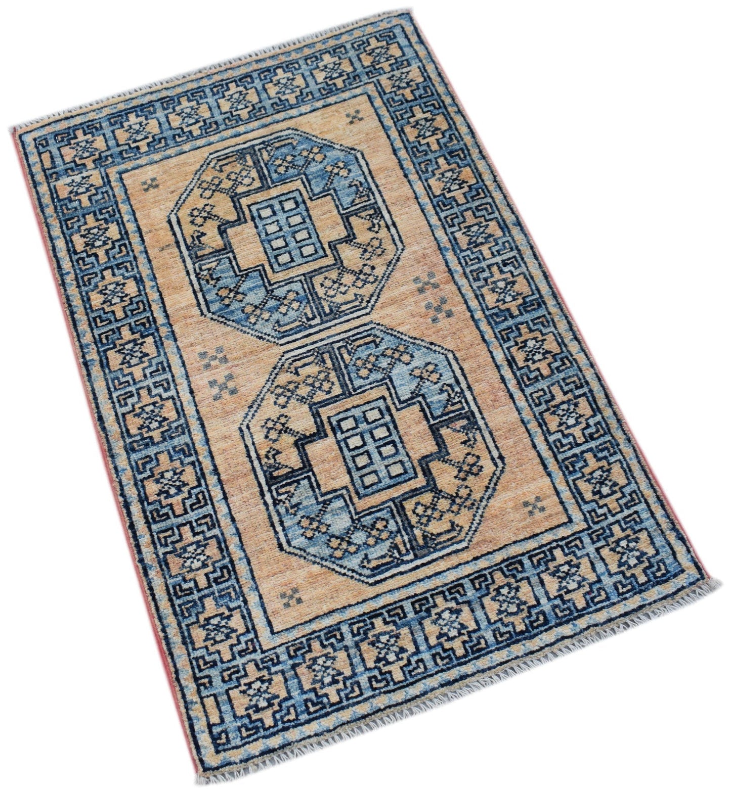 A handmade Afghan Chobi rug featuring two blue geometric medallions on a tan wool field.