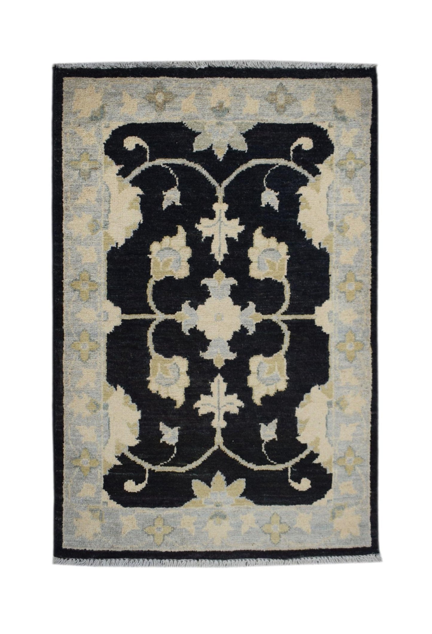 A handmade Afghan Chobi rug featuring a black central field with cream and blue floral motifs.