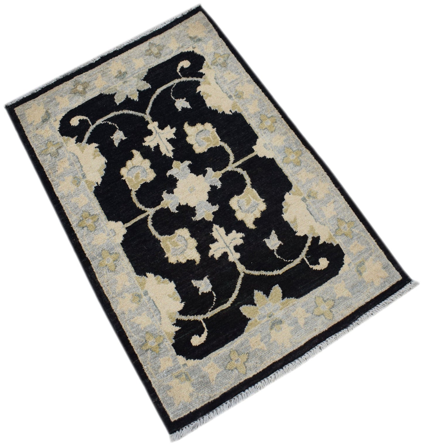 A handmade Afghan Chobi rug featuring a black central field with floral patterns and a light border.