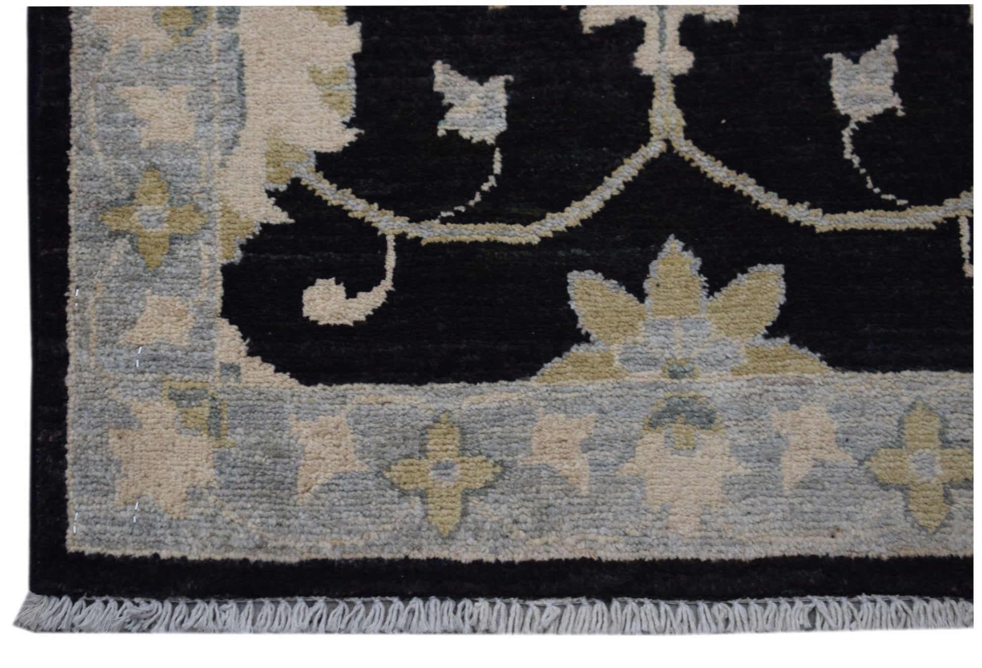 A handmade Afghan Chobi rug featuring a black field with floral patterns and a light grey border.