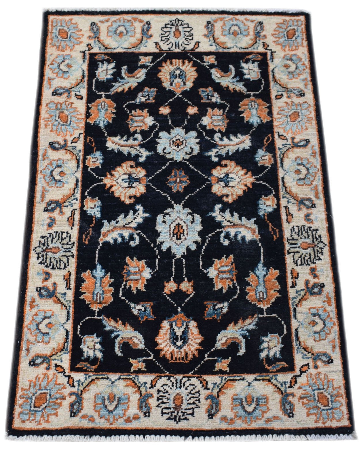 A handmade mini Afghan Chobi rug featuring a floral pattern in blue and orange on a black field.