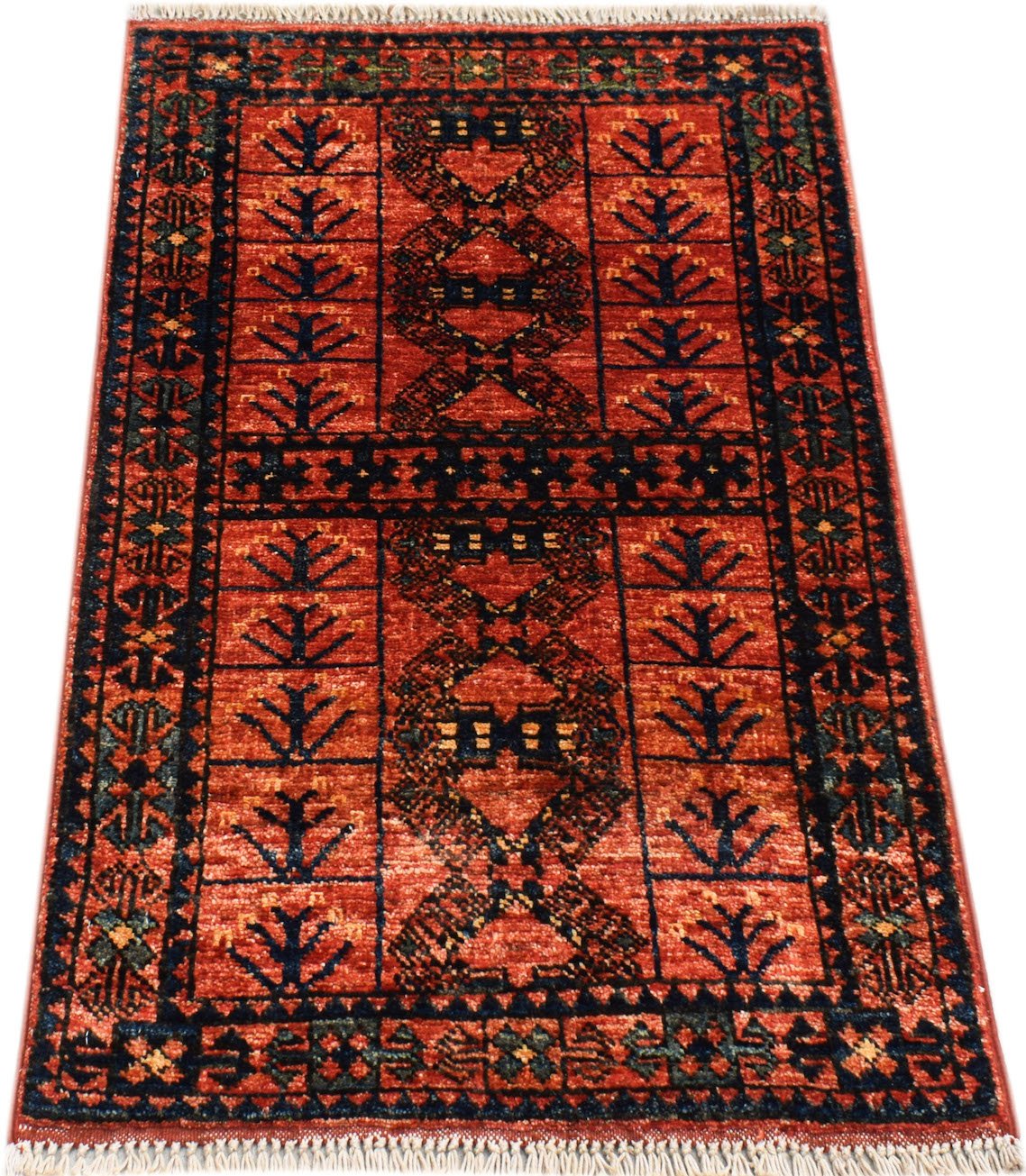 A handmade Afghan Chobi rug featuring a geometric pattern in shades of red and dark blue.