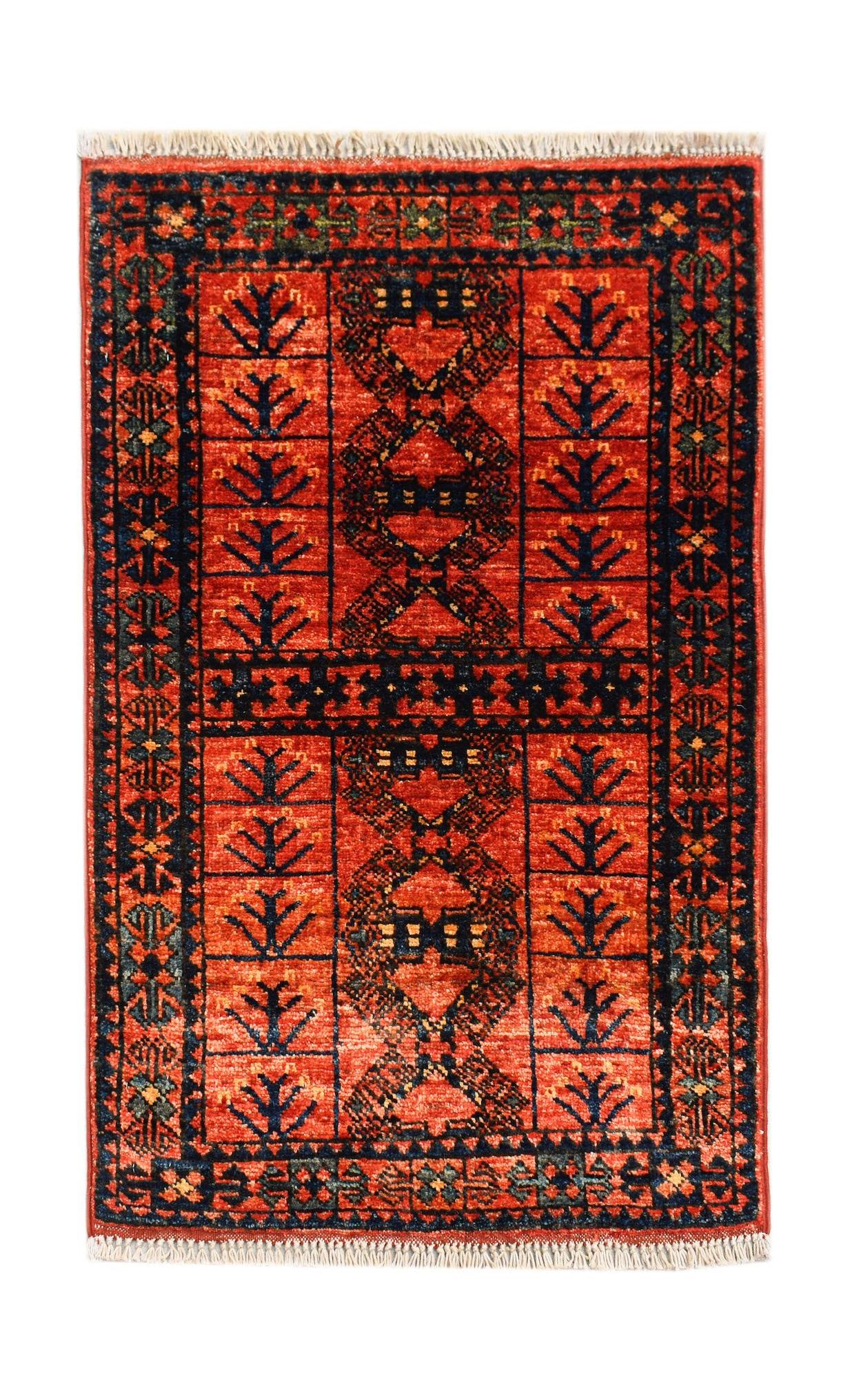 A handmade mini Afghan Chobi rug featuring a geometric pattern in shades of red and dark blue.