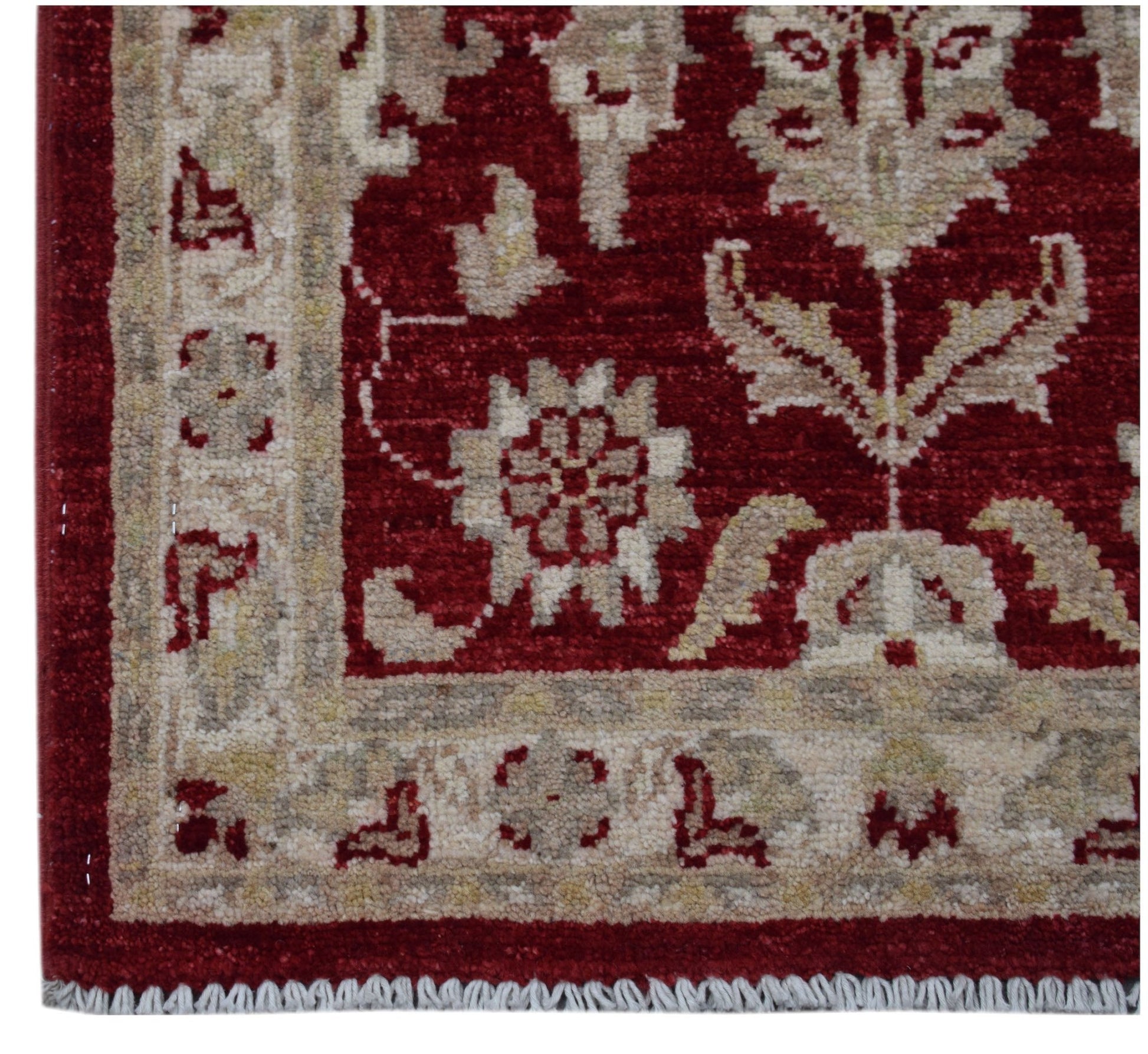 A handmade Afghan Chobi rug featuring a traditional floral pattern in red and beige tones.