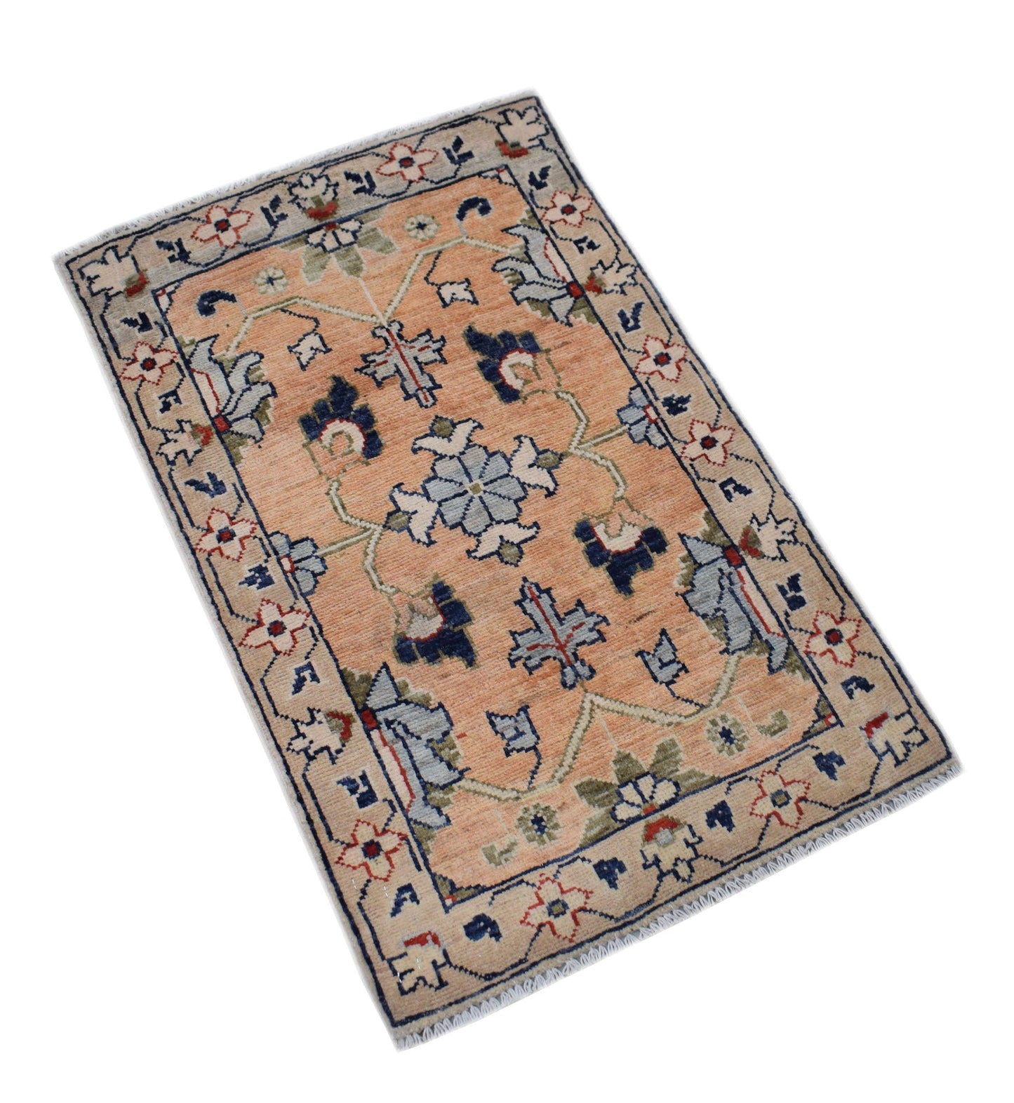 A handmade Afghan Chobi rug featuring a floral pattern in shades of peach, blue, and cream.
