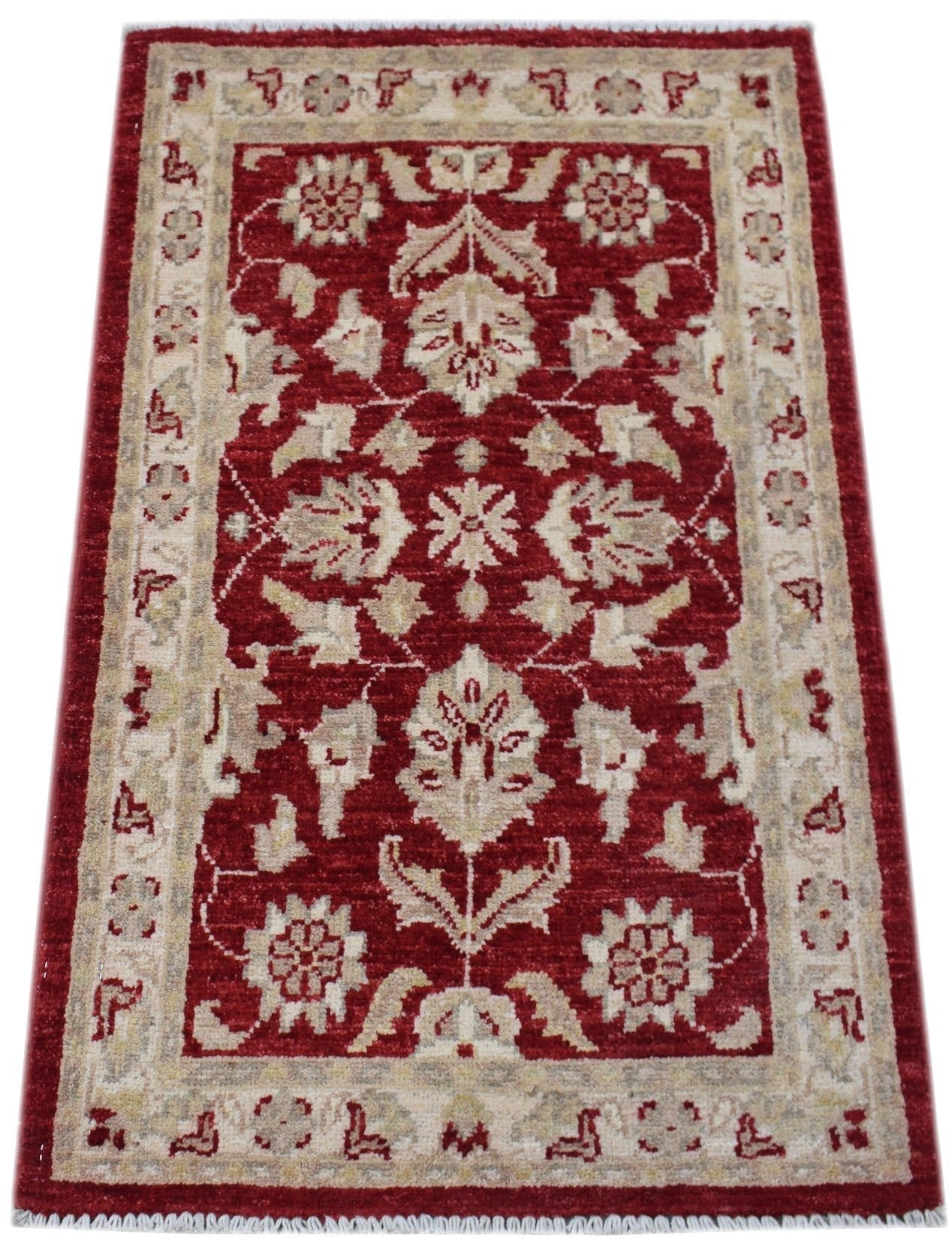 A handmade wool Afghan Chobi rug featuring a floral pattern in red and beige tones.