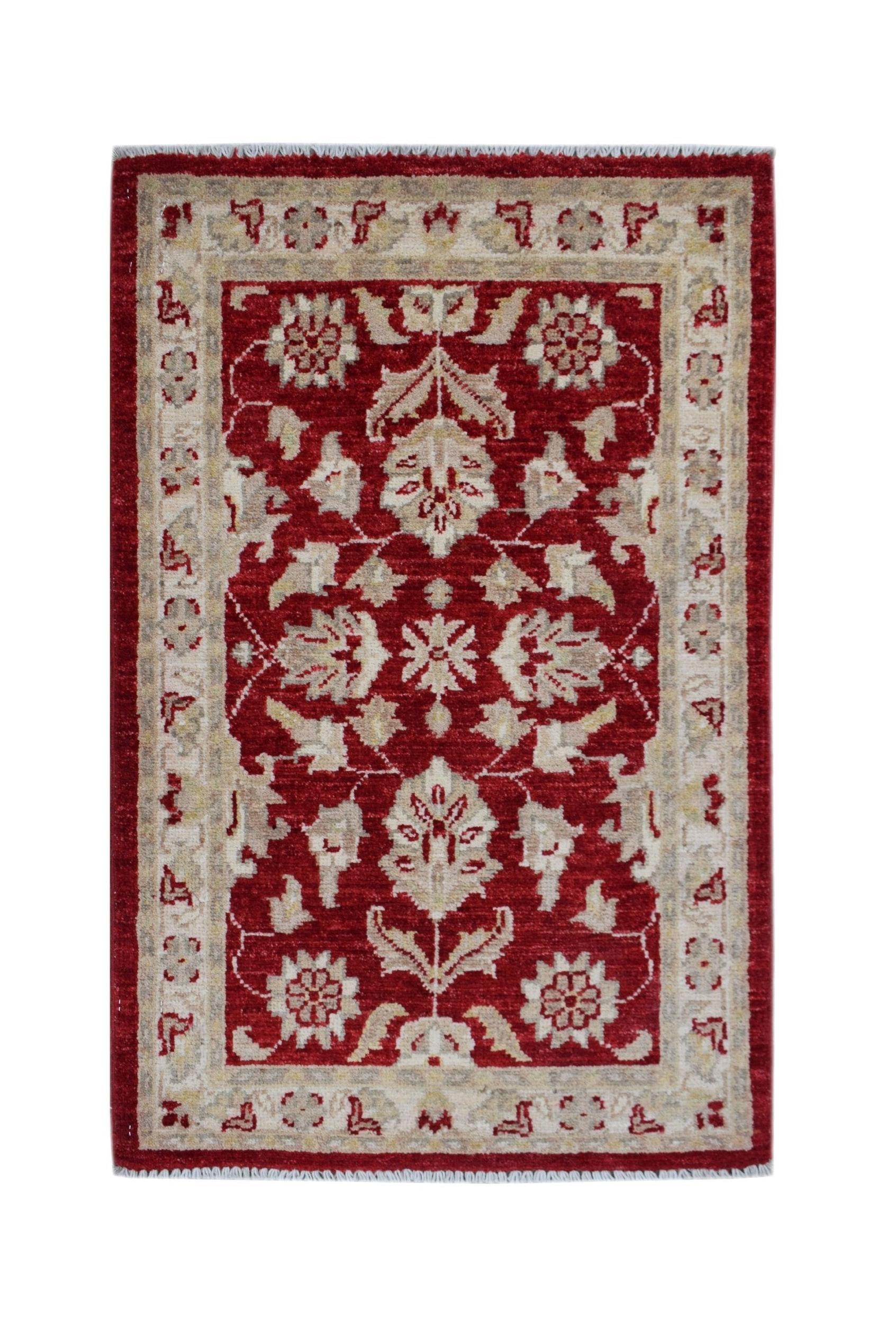 A rectangular handmade Afghan Chobi rug featuring a floral pattern in red and beige wool.