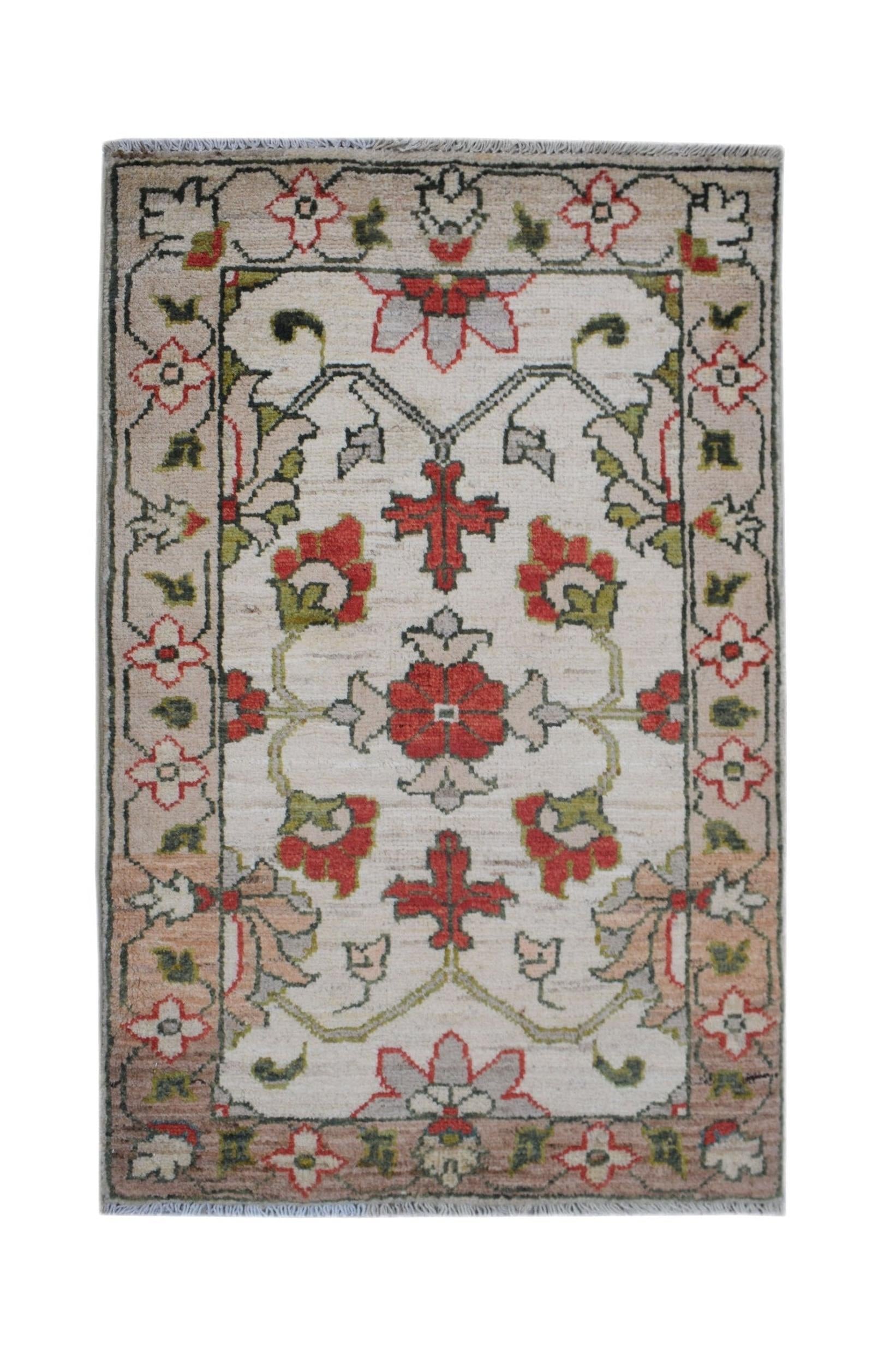 A handmade Afghan Chobi rug featuring a floral pattern in red, green, and beige on a cream field.