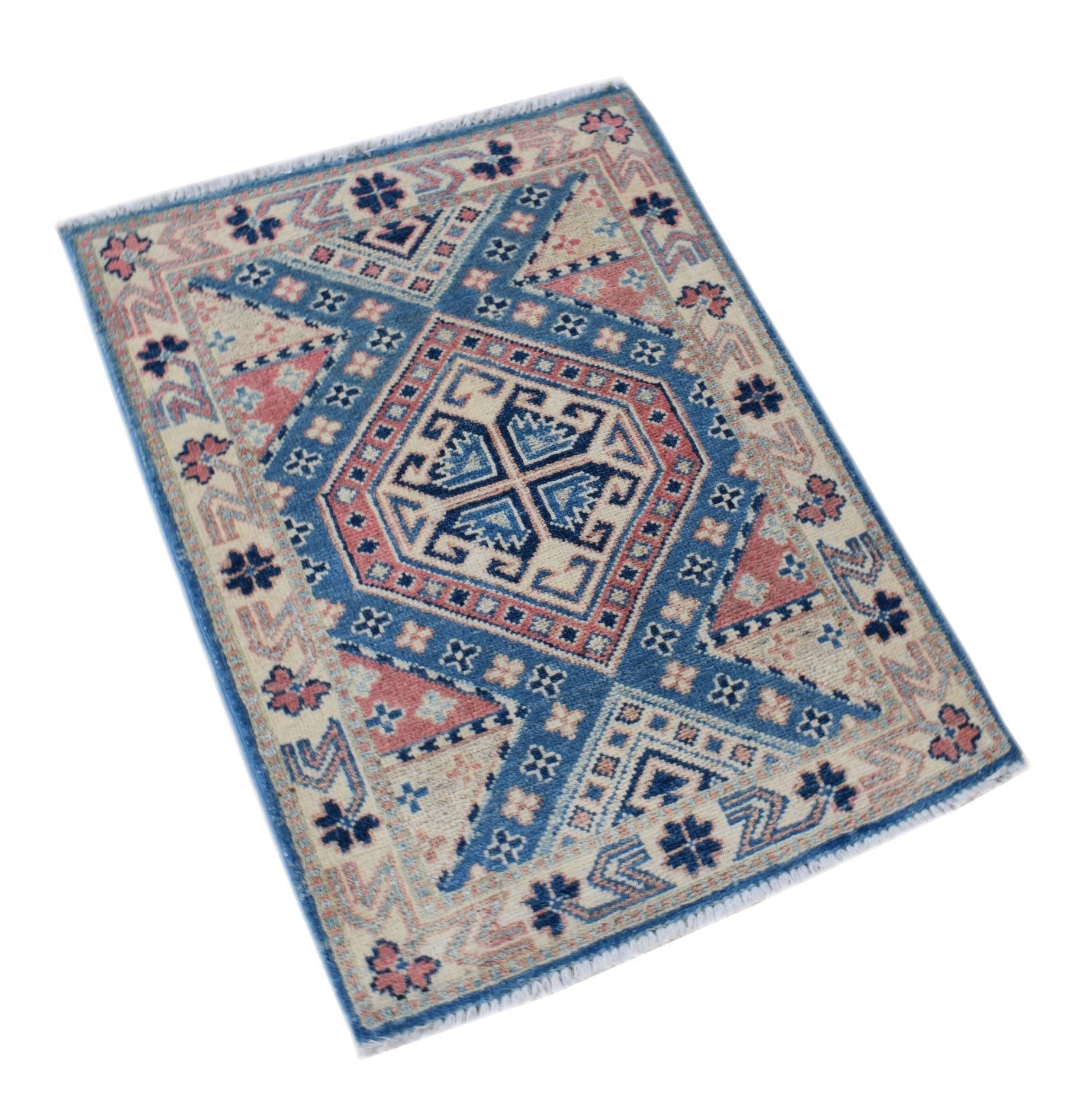 A handmade mini Afghan Kazakh rug featuring a geometric pattern in blue, pink, and cream wool.