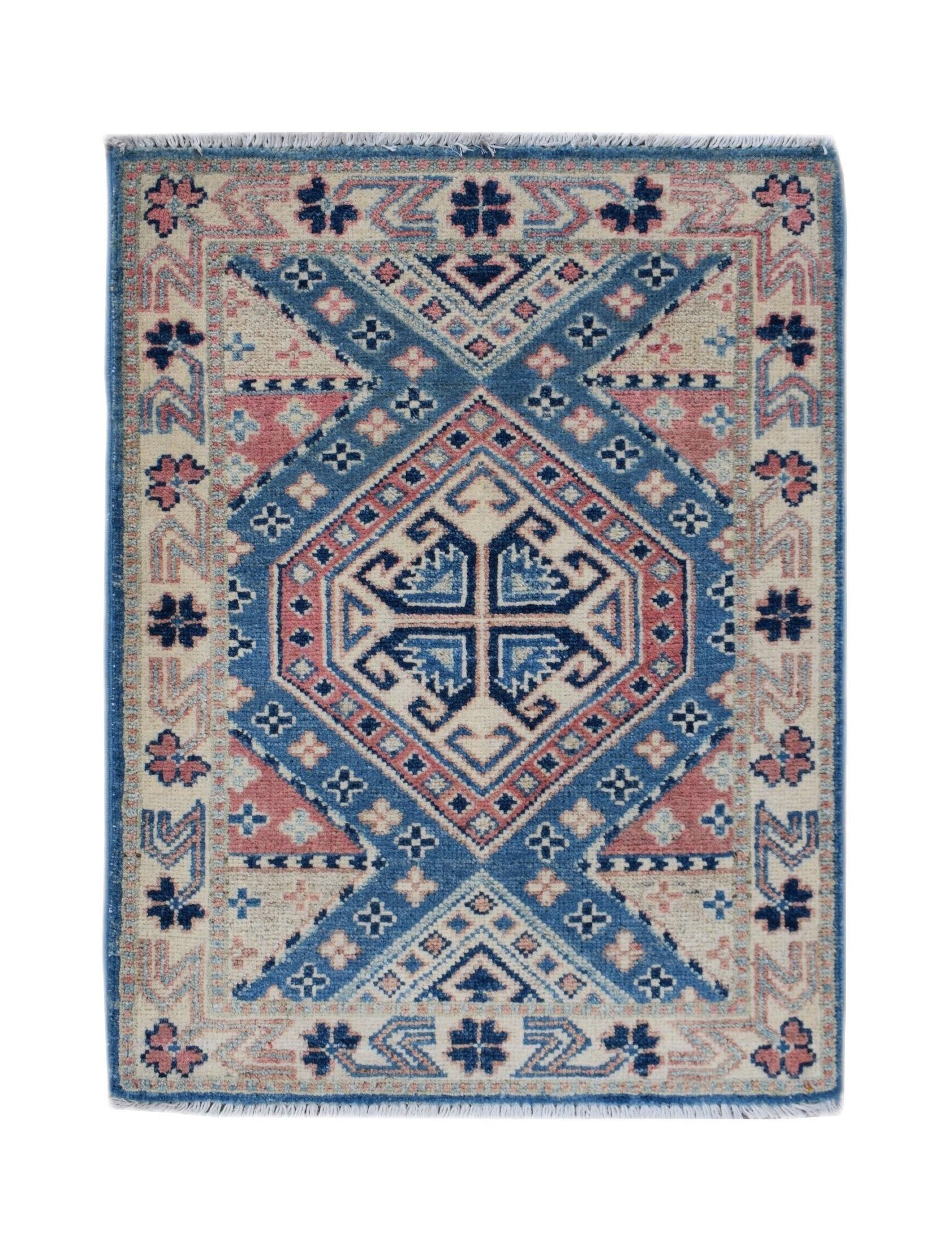A handmade Afghan Kazakh rug featuring a geometric diamond pattern in blue, pink, and cream.