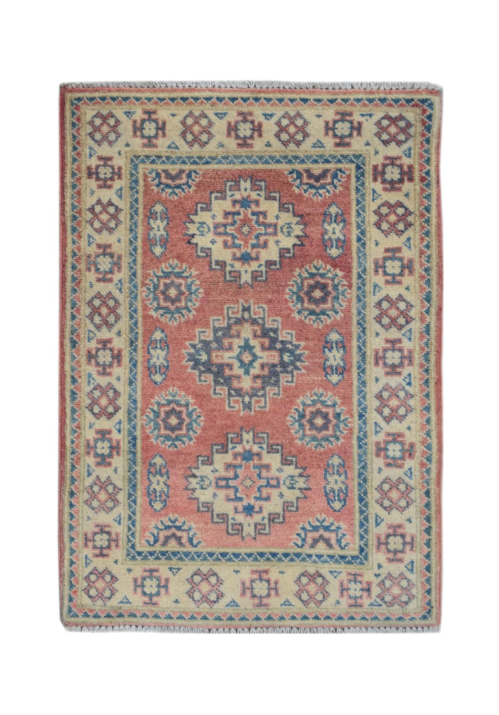 A handmade Afghan Kazakh rug featuring geometric patterns in shades of red, blue, and cream.