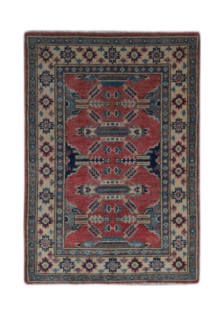 A handmade wool Afghan Kazakh rug featuring a geometric pattern in red, blue, and cream tones.