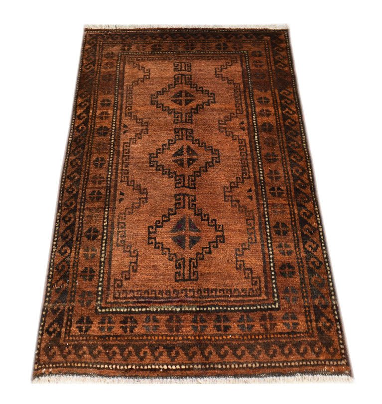 A handmade vintage Afghan Baluch rug featuring geometric diamond motifs in brown and dark tones.