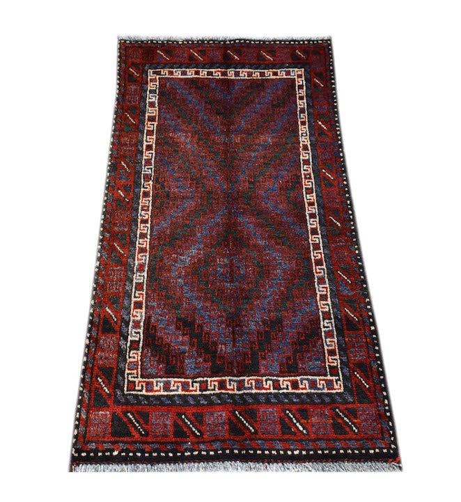 A rectangular handmade Afghan Baluch rug featuring a geometric diamond pattern in red and blue.