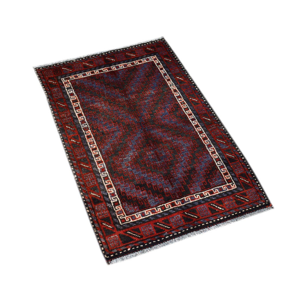 A handmade vintage Afghan Baluch rug featuring dark red, blue, and black geometric patterns.