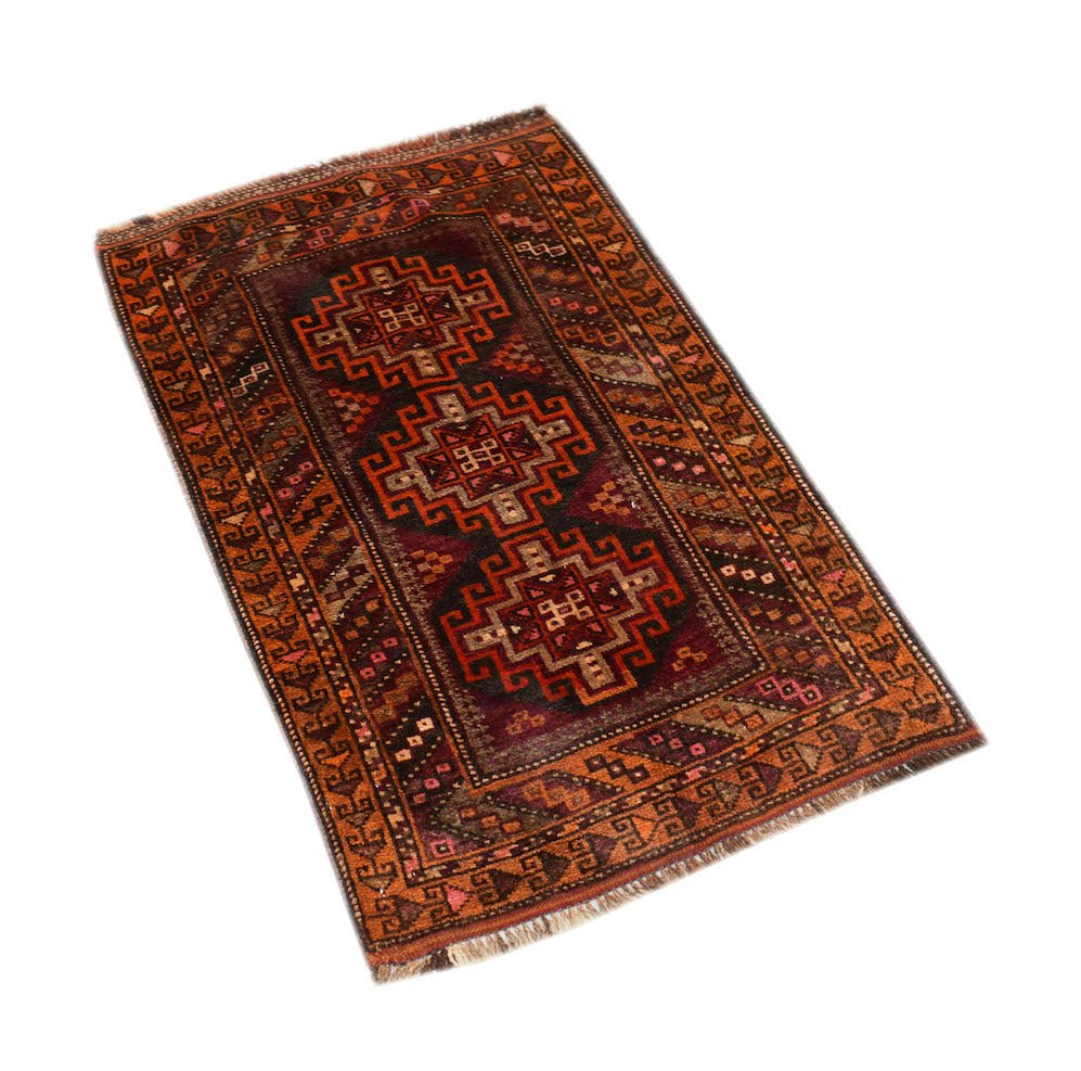 A vintage handmade Afghan Baluch rug featuring three geometric medallions in deep red and brown.