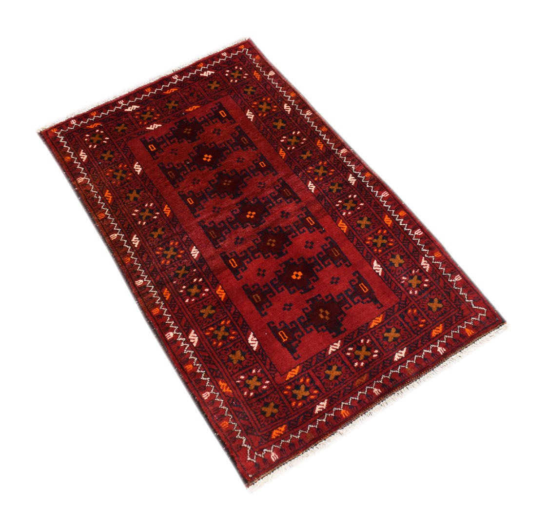 A handmade vintage Afghan Baluch rug featuring dark red tones and geometric tribal patterns.